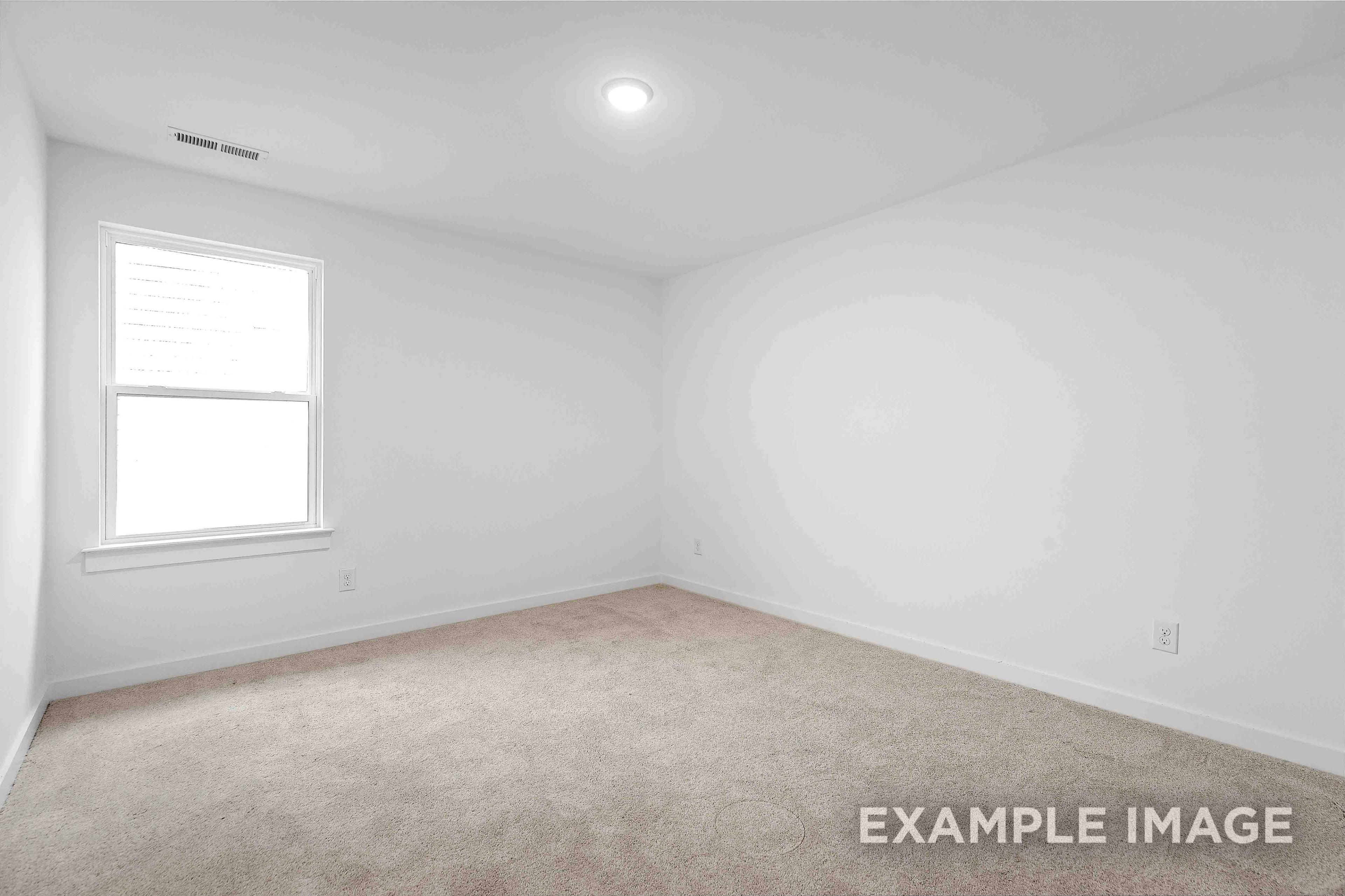 Spacious empty bedroom in The Charleston home design featuring white walls, large window with blinds, and beige carpet