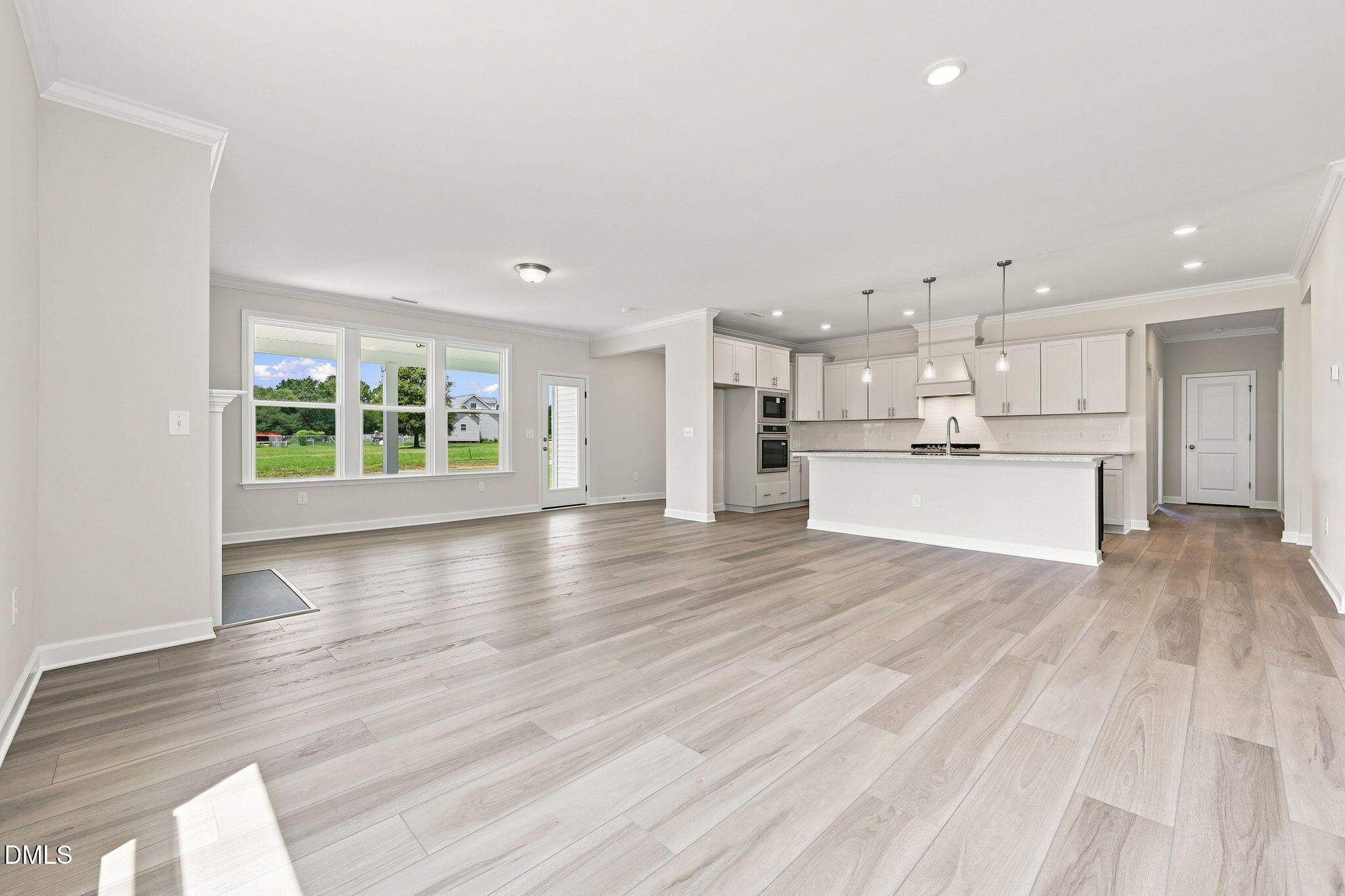 Open-concept living room and modern kitchen in The Magnolia B floor plan at Retreat at North Main, Lillington, NC.
