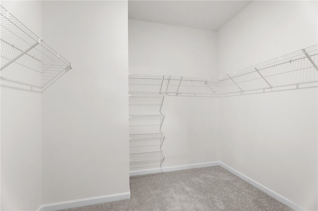 Spacious walk-in closet with white wire shelving in The Stella D floor plan at Silver Oak, Cusseta, Alabama.