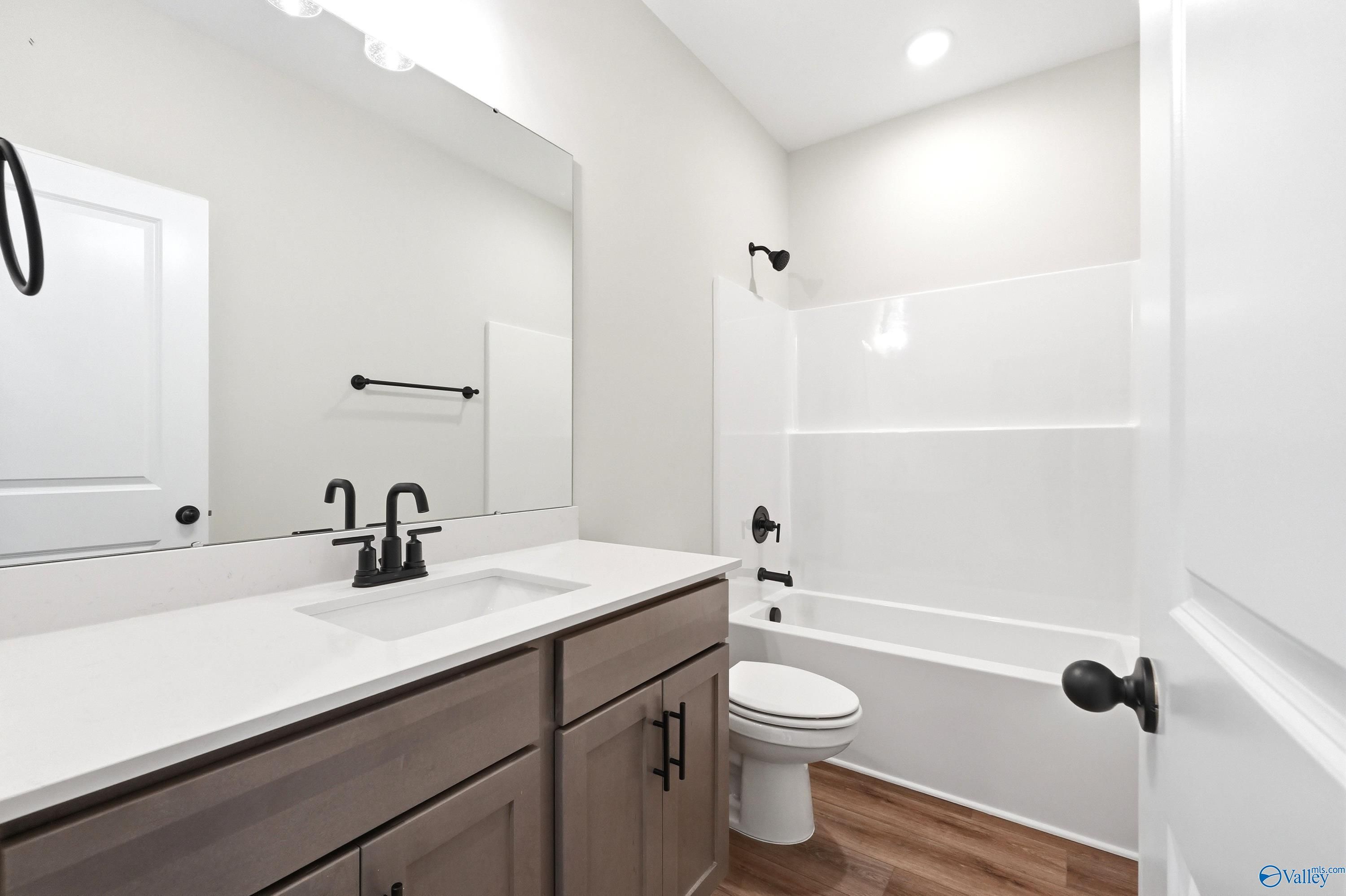 Modern bathroom with sleek vanity, matte black fixtures, and tub-shower combo in Davidson Homes The Daphne, Hazel Green.