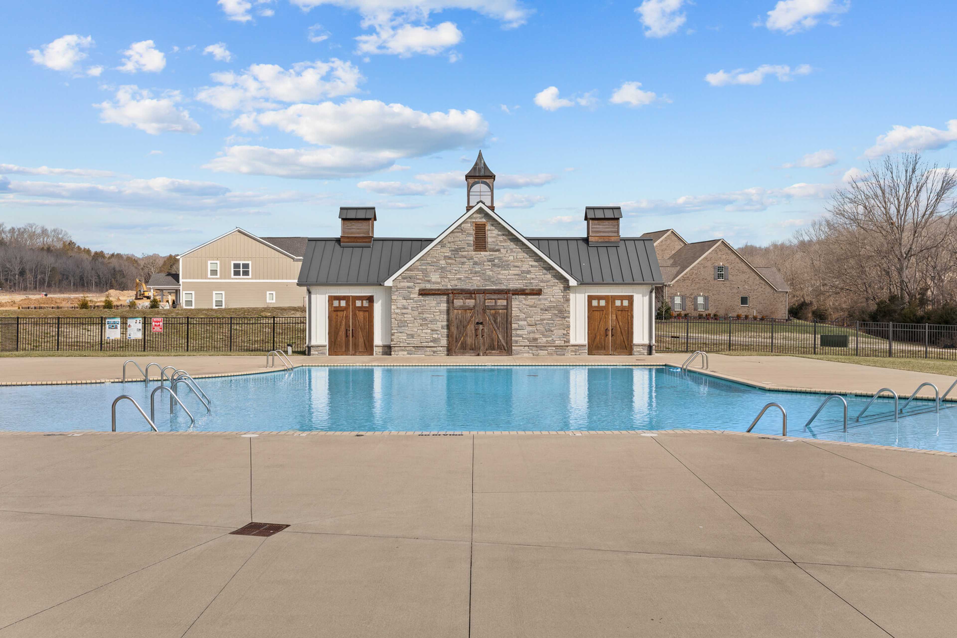 Resort-style swimming pool and clubhouse at Carellton in Gallatin TN with clock steeple, barn doors and fenced deck