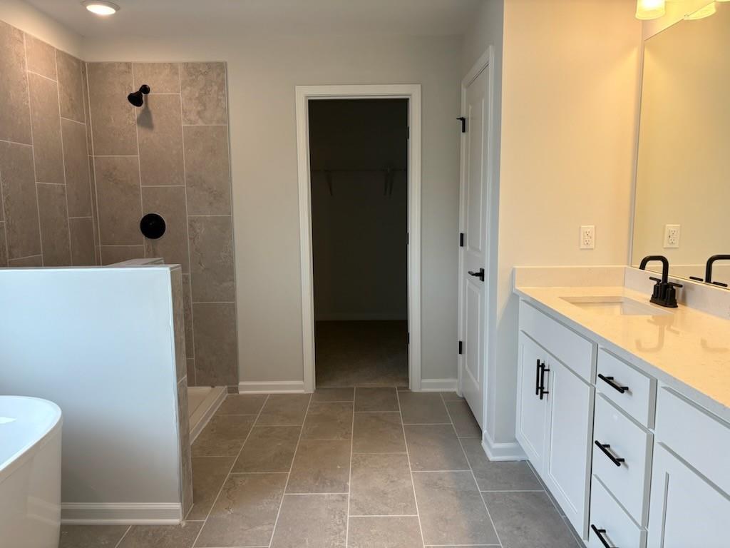 Modern master bathroom featuring walk-in tiled shower, double white vanity, and neutral tones in Davidson Homes The Hickory B, Winder, GA