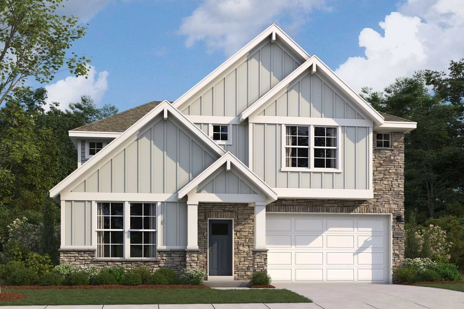 The Radiance two-story home elevation with stone accents, gray siding, two-car garage, and lush landscaping by Evermore Homes in Perry, GA