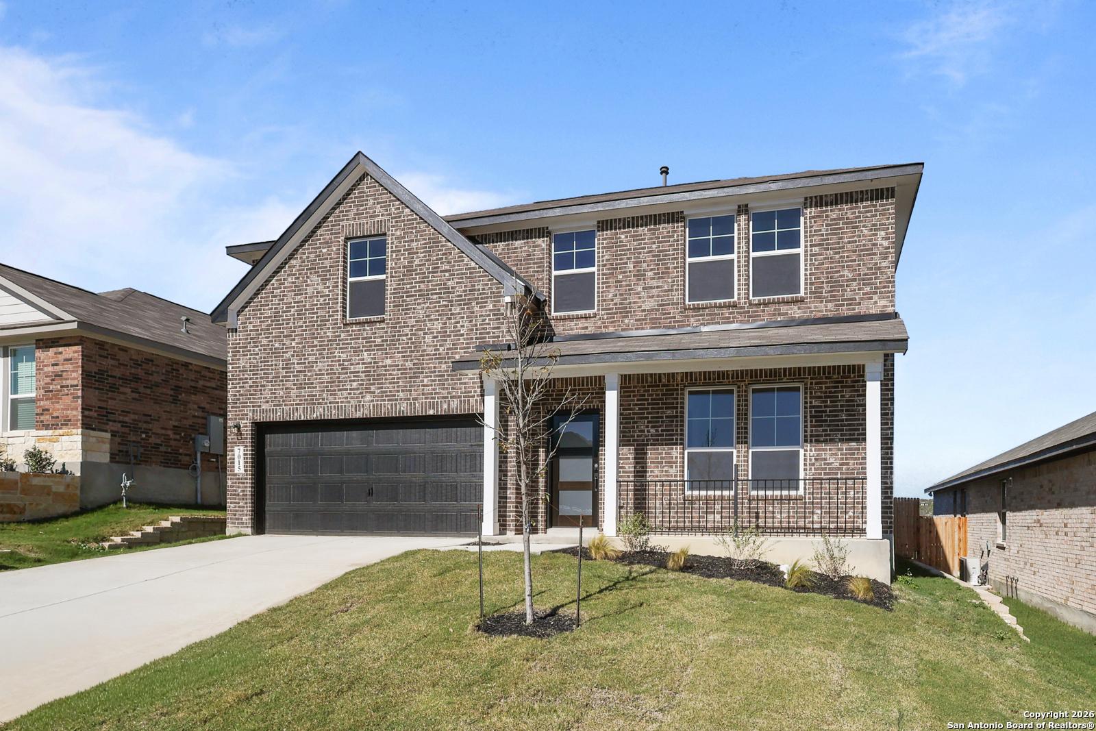 Two-story brick home with 2-car garage, covered porch, and lush lawn in Comanche Ridge, San Antonio, Texas - Davidson Homes The Murray K