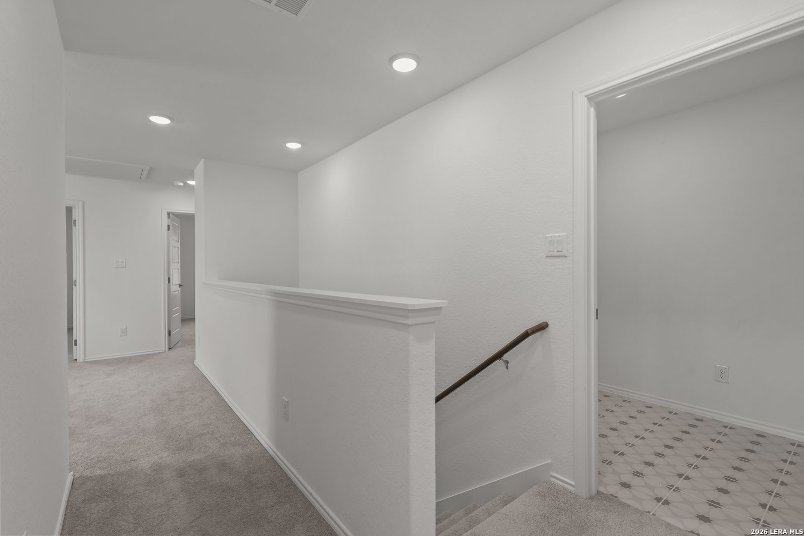 Bright carpeted upstairs landing and staircase in The Gillian C floor plan by Davidson Homes in San Antonio, Texas.