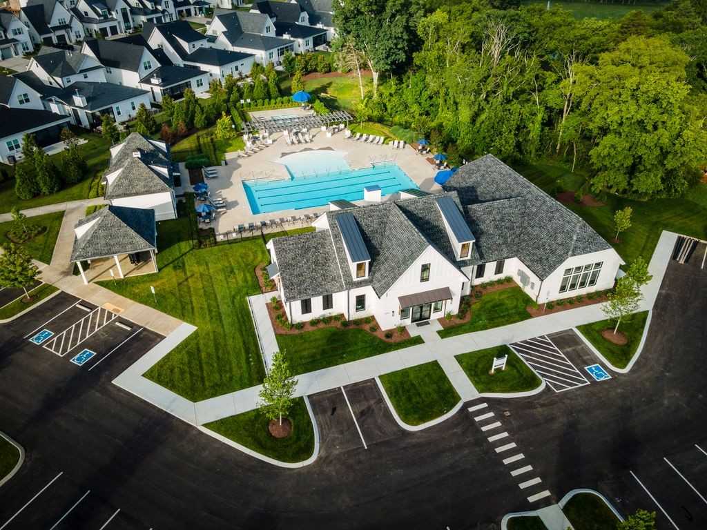 Aerial view of Shelton Square resort-style pool, clubhouse with lounge chairs, and modern homes amid lush greenery in Murfreesboro, Tennessee