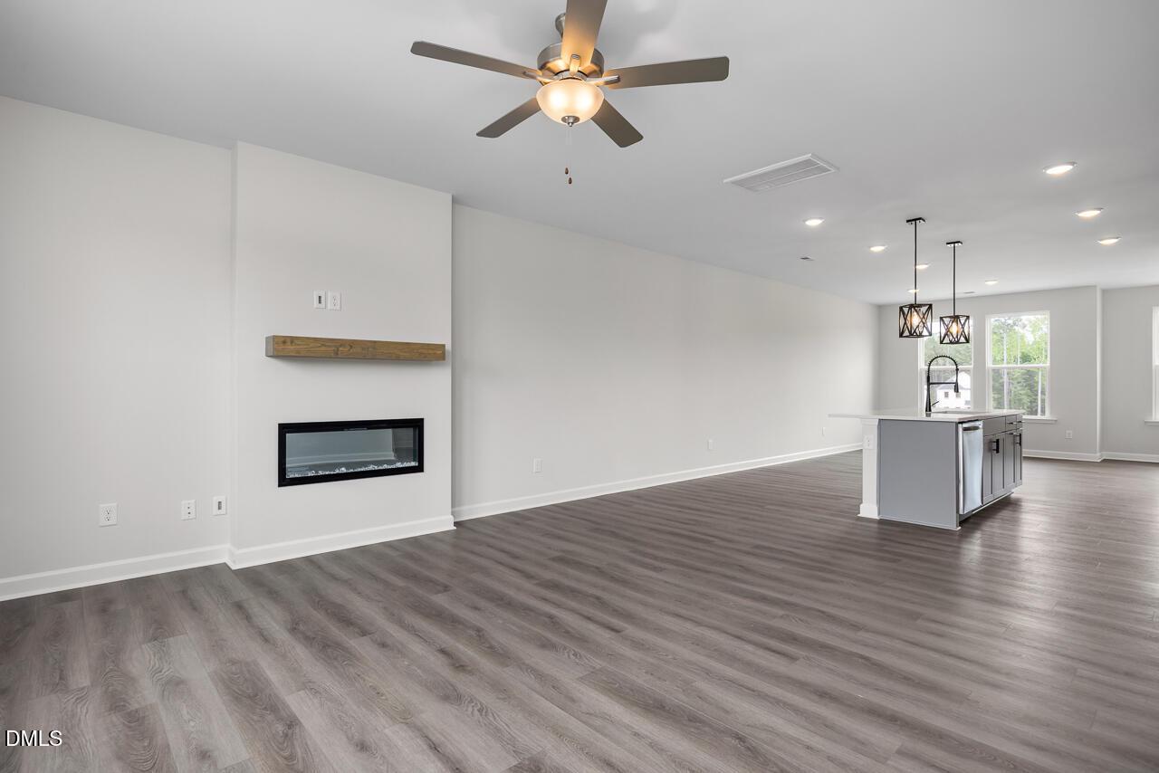 Open-concept living room with modern fireplace in The Mitchell Interior floor plan at Forestville Yard, Knightdale, NC.