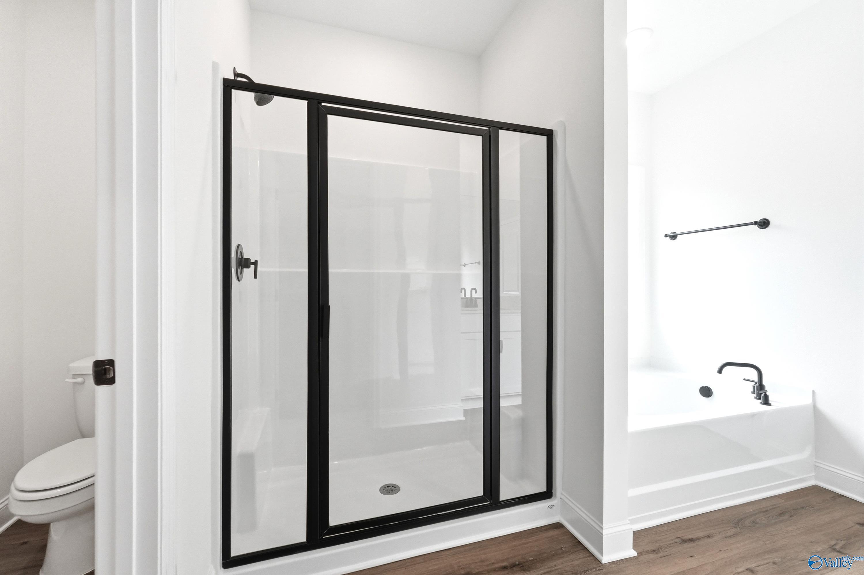 Modern bathroom with glass walk-in shower and separate soaking tub in The Daphne C floor plan by Davidson Homes.