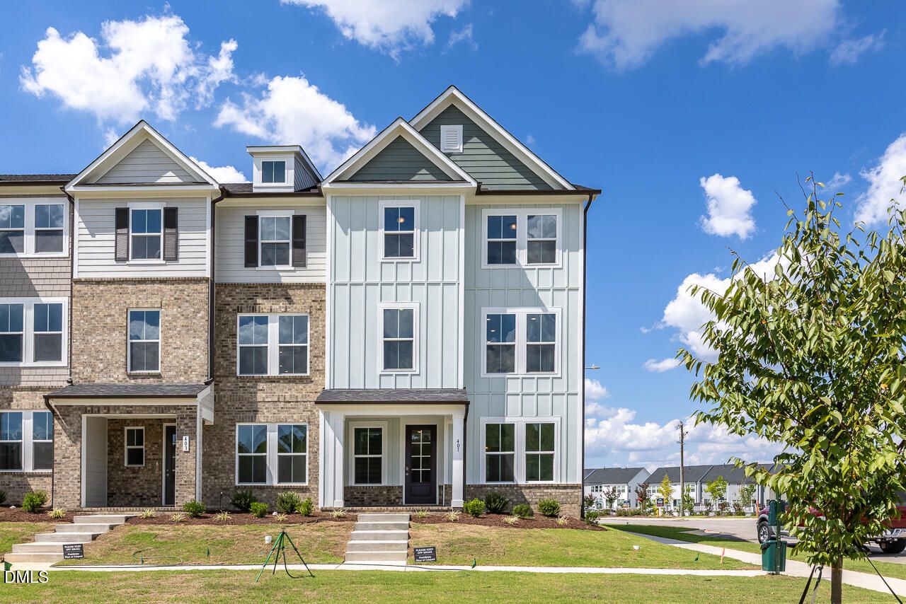 Three-story brick and siding townhome exterior with gabled roofs at Forestville Yard Townhomes, Davidson Homes in Knightdale, North Carolina