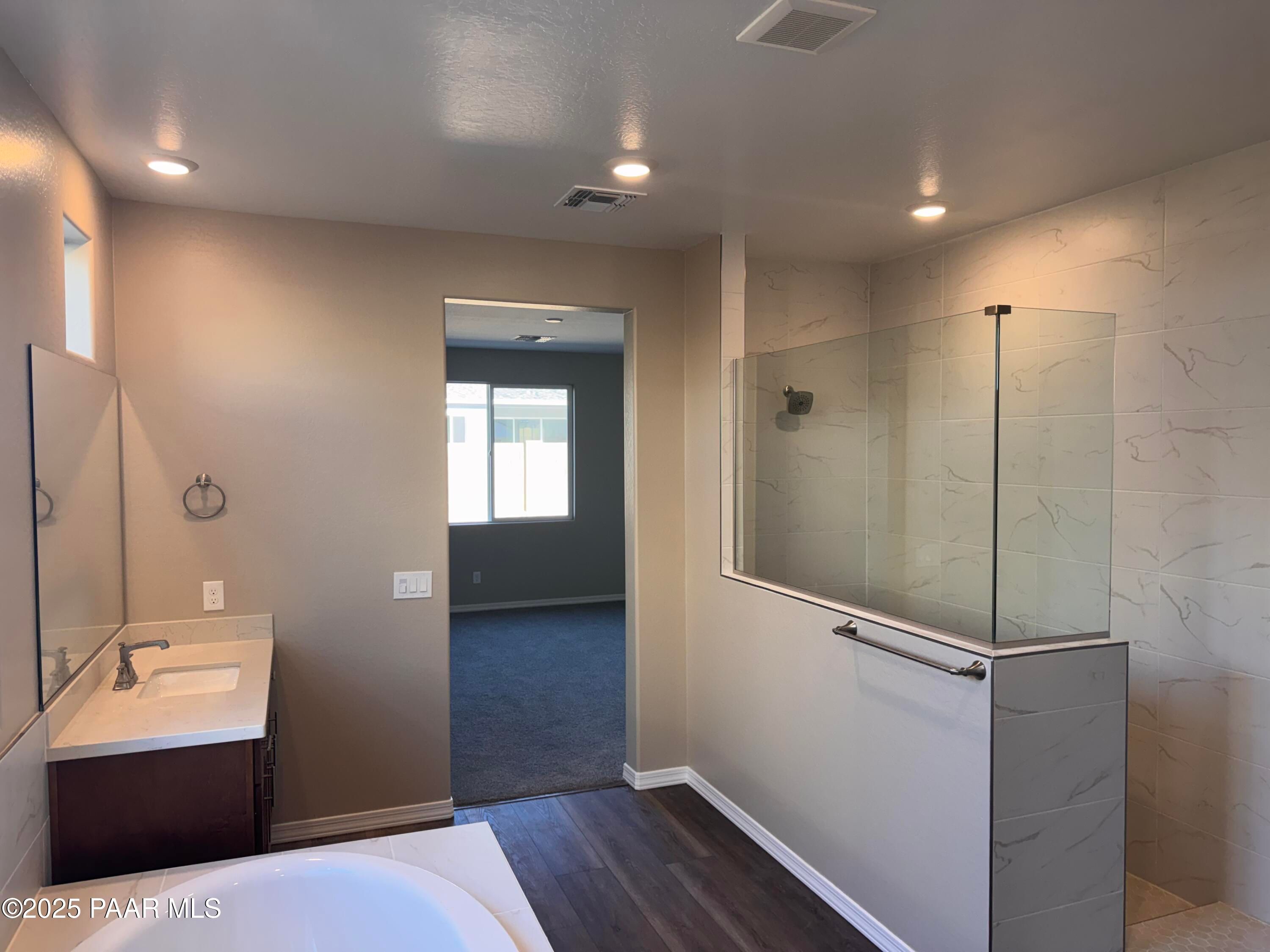 Elegant master bathroom with frameless glass shower, freestanding tub, and quartz vanity in Davidson Homes Sunrise II A, Prescott AZ