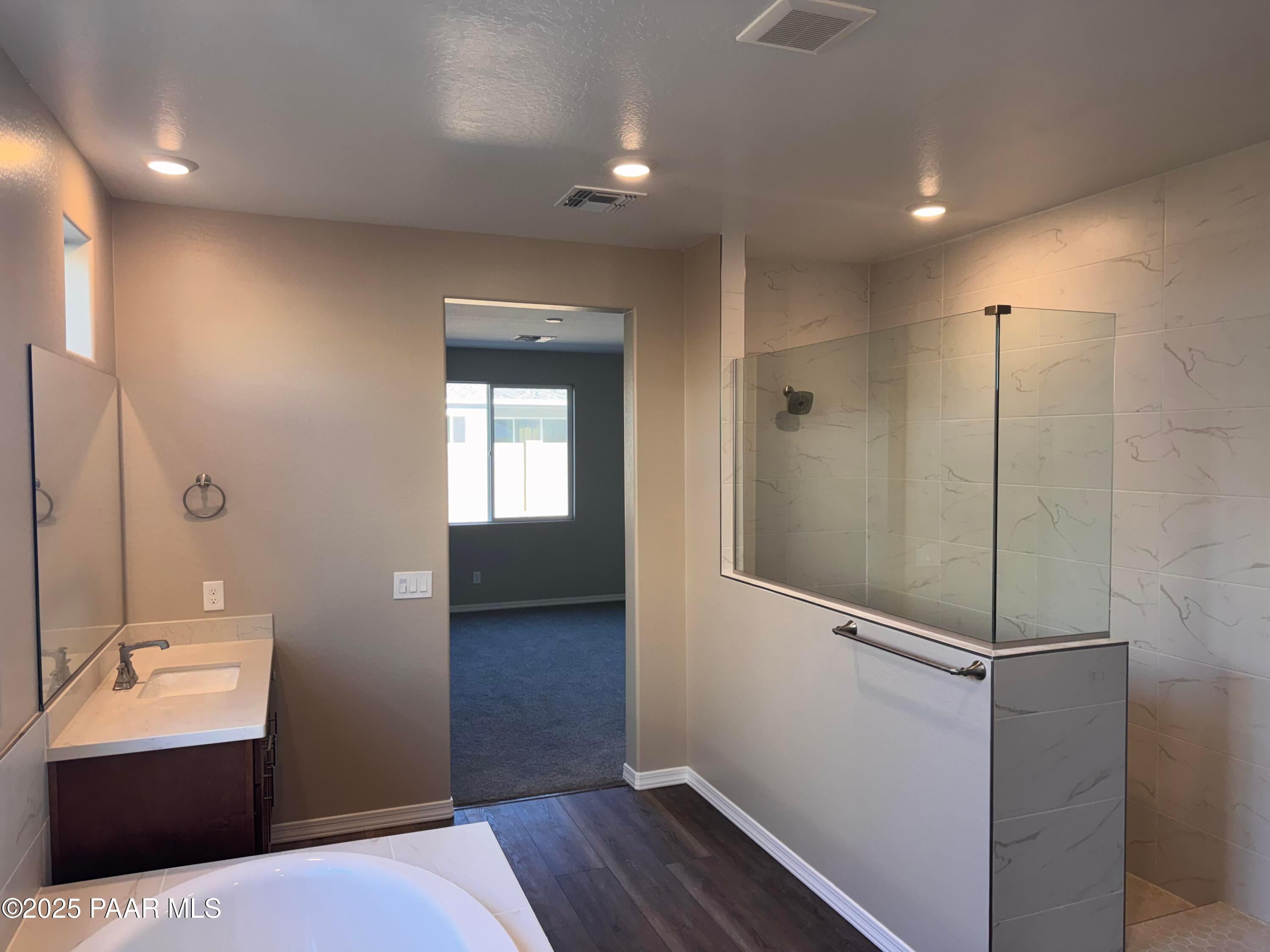 Elegant master bathroom with frameless glass shower, freestanding tub, and quartz vanity in Davidson Homes Sunrise II A, Prescott AZ
