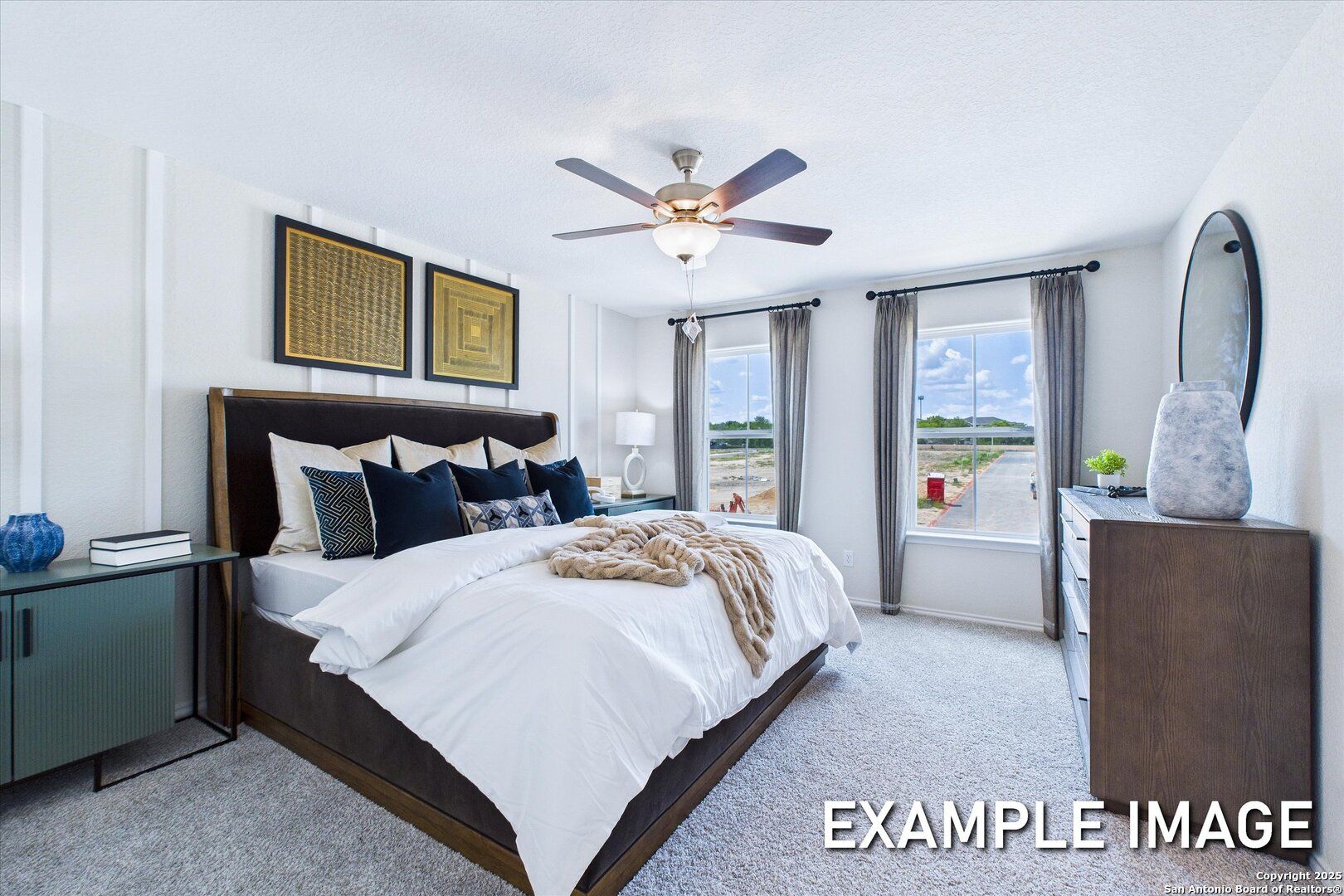 Elegant master bedroom with upholstered king bed, ceiling fan, and large curtained windows in Davidson Homes The Gillian B, San Antonio