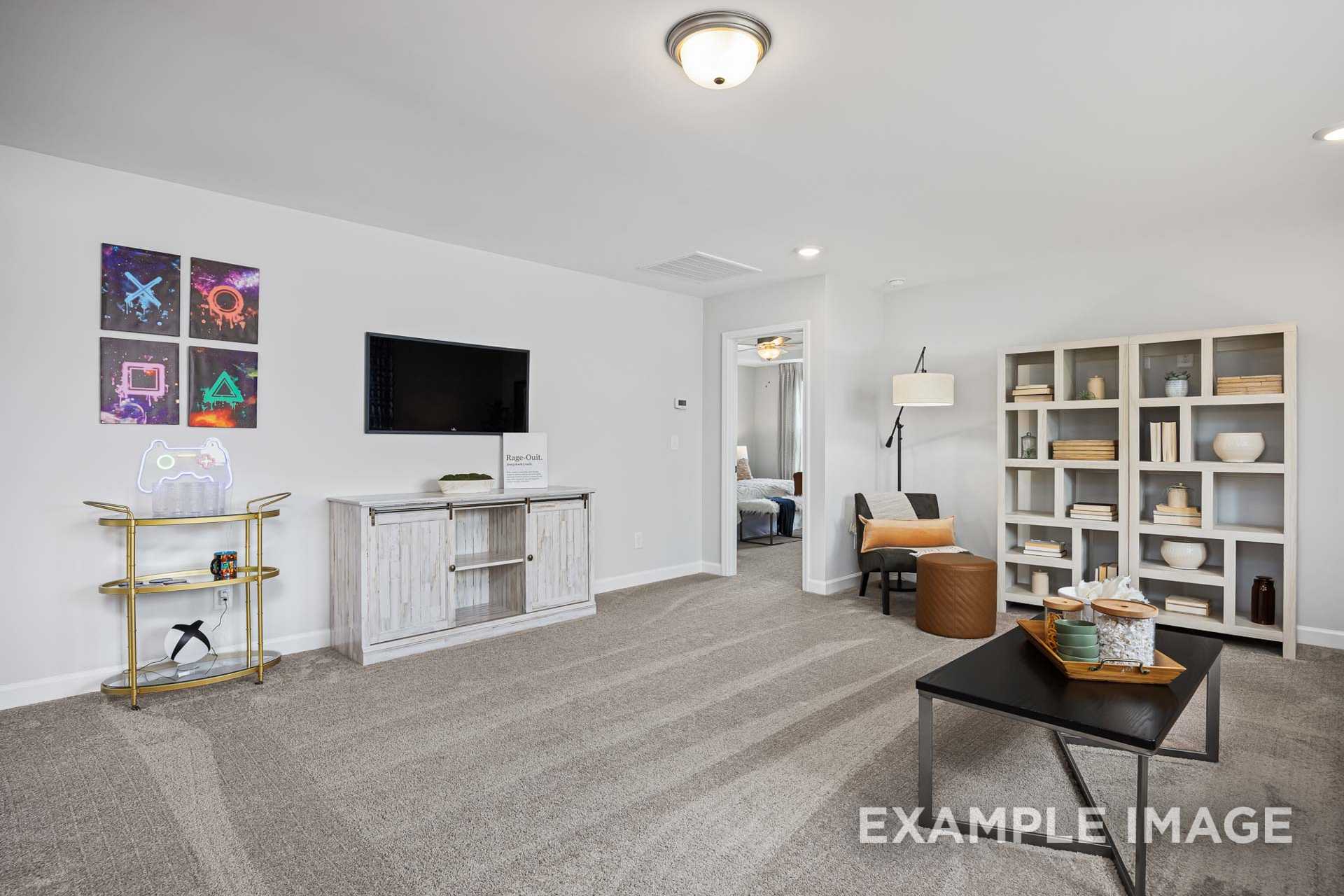 Spacious modern living room in The Adalynn A showcasing wall-mounted TV, open bookshelves, and neutral decor