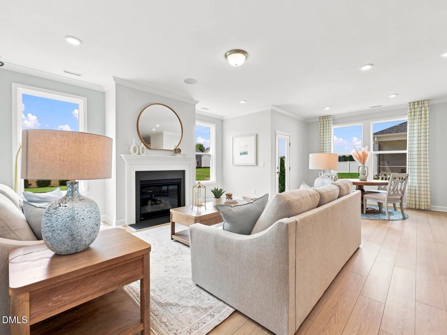 Bright open-concept living room with cozy fireplace in The Daphne C floor plan at Woodland Crossing, Zebulon, NC.