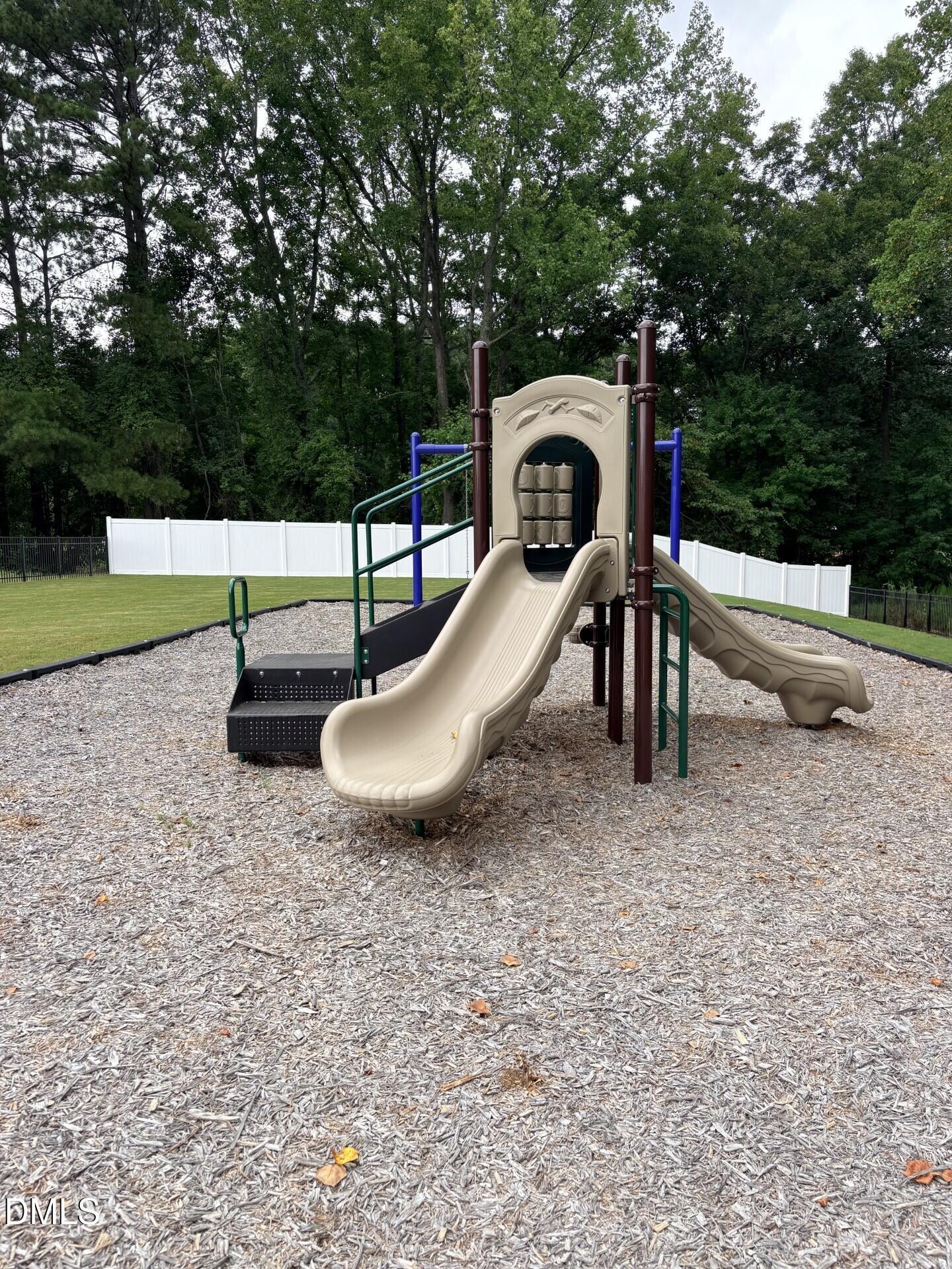 Community playground equipment with slides at Woodland Crossing in Zebulon, North Carolina by Davidson Homes.