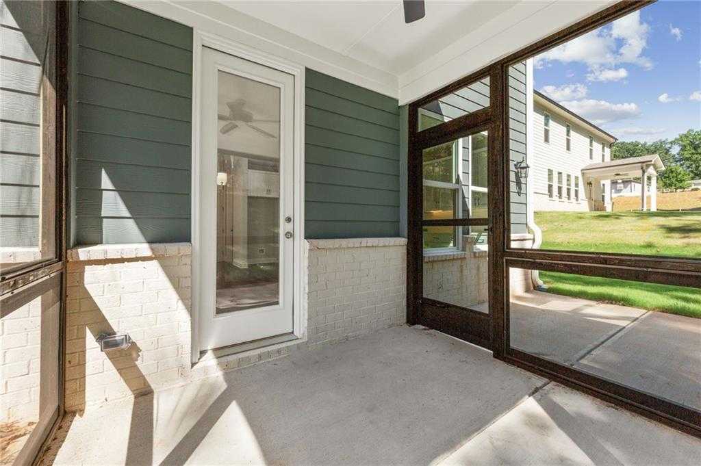 Screened porch with ceiling fan, glass sliding doors, and green siding overlooking lush backyard in The Danbury E, Buford, GA
