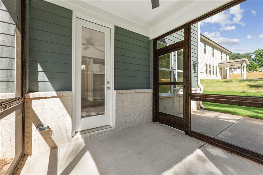 Screened porch with ceiling fan, glass doors, and backyard view in Davidson Homes The Danbury E, Buford, Georgia