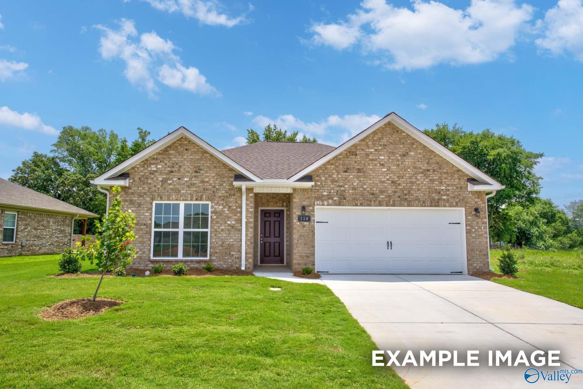 Single-story brick home with 2-car garage, large windows, and landscaped yard in Ricketts Farm, Athens, Alabama