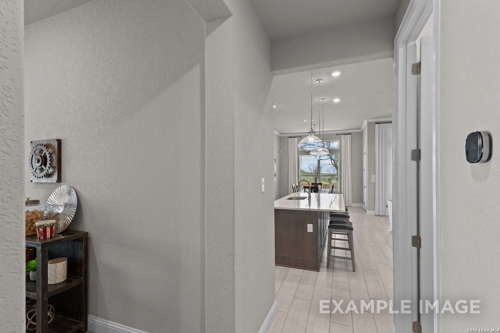 View from foyer into open-concept kitchen and island in The Garner C floor plan at The Reserve at Potranco Oaks.