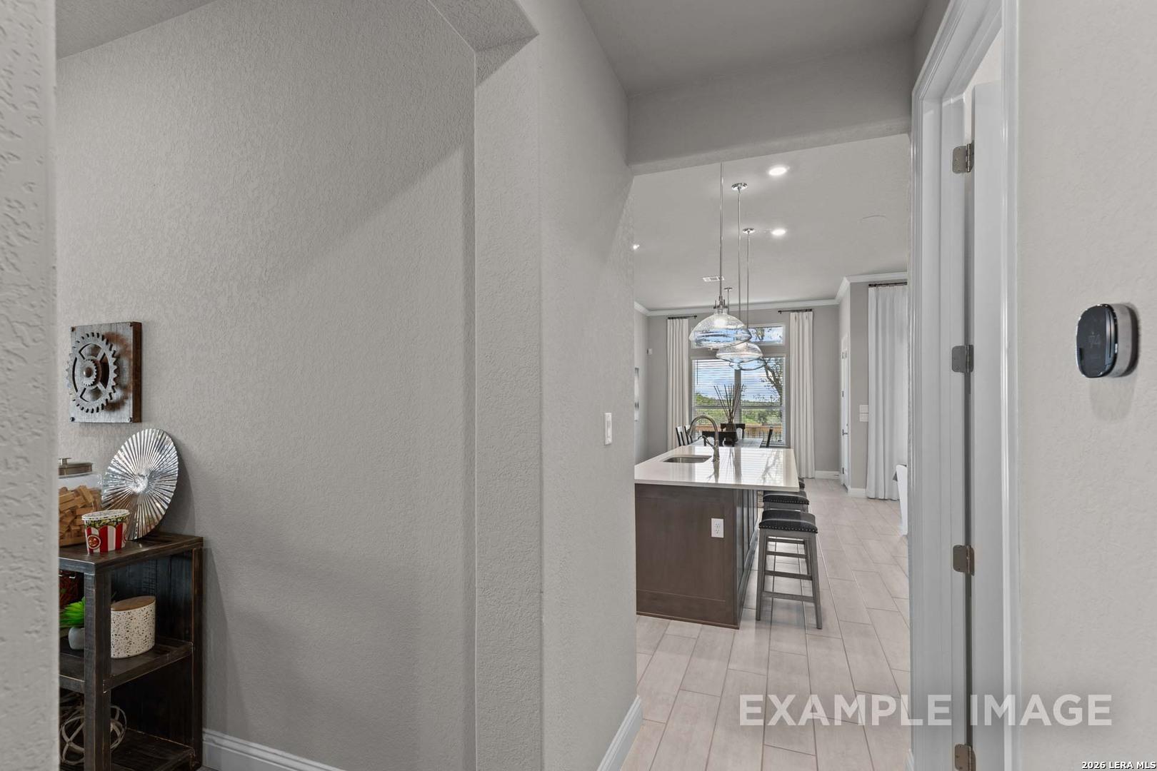 View from foyer into open-concept kitchen and island in The Garner C floor plan at The Reserve at Potranco Oaks.