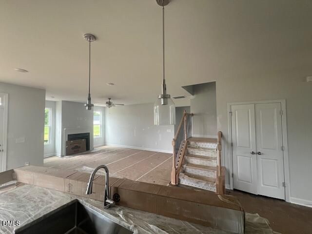 Open-concept Ash B floor plan with kitchen island, fireplace, and staircase in Retreat at North Main, Lillington, NC.