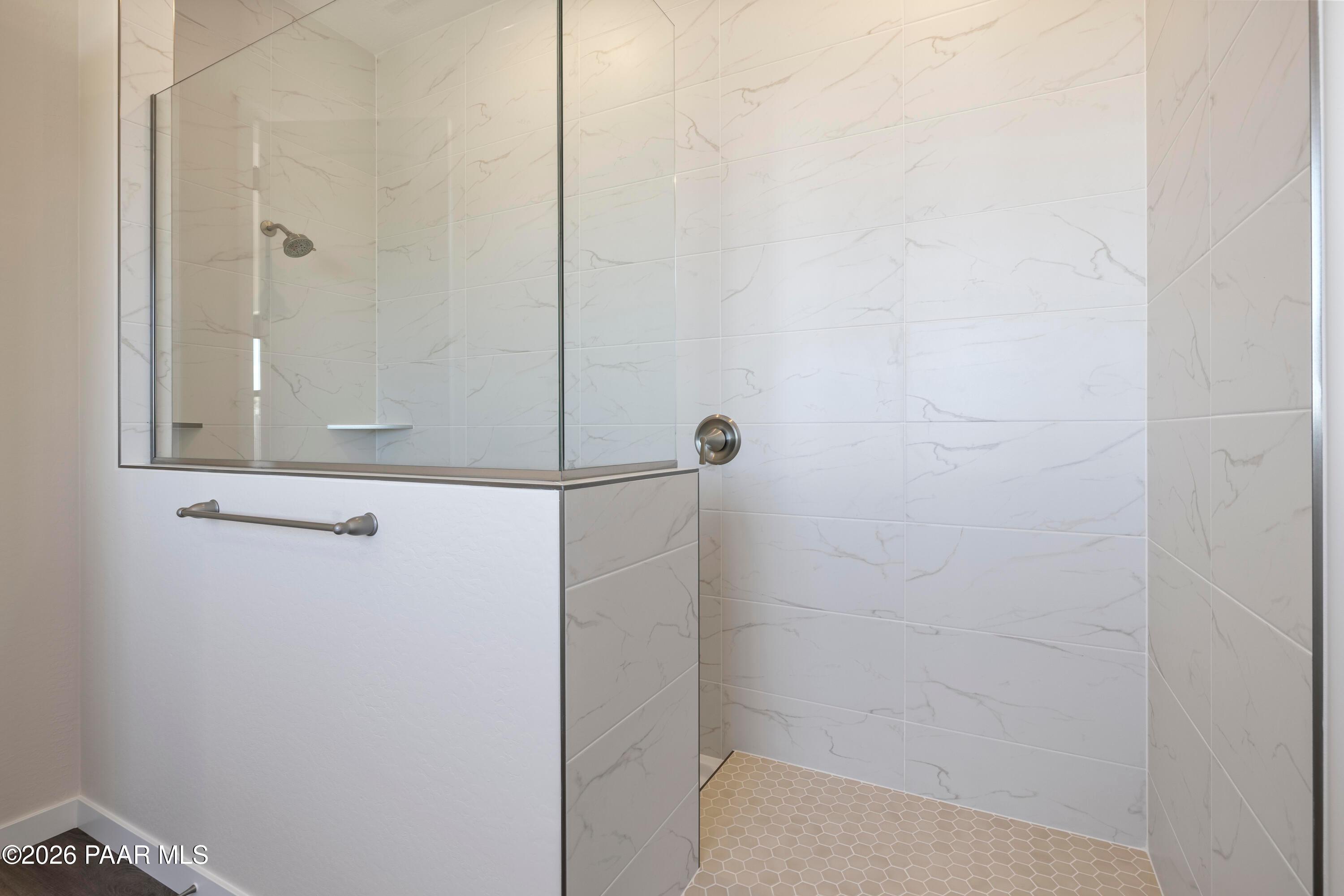 Modern frameless glass shower with white subway tile and rainfall head in The Soleil E master bath, Davidson Homes, Prescott AZ