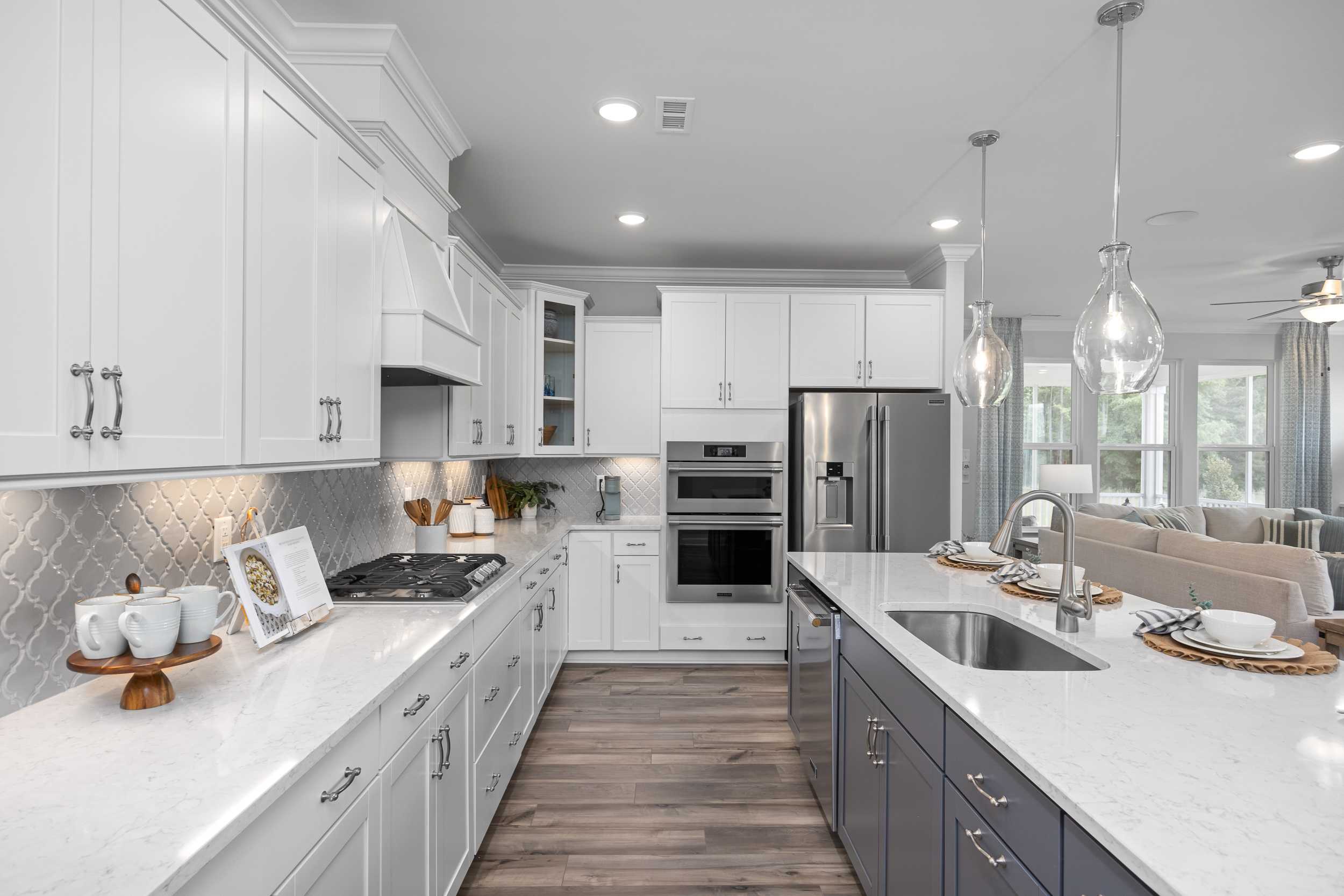 Spacious open-concept kitchen at Tobacco Road in Angier NC with white shaker cabinets, navy island, quartz counters, and stainless appliances