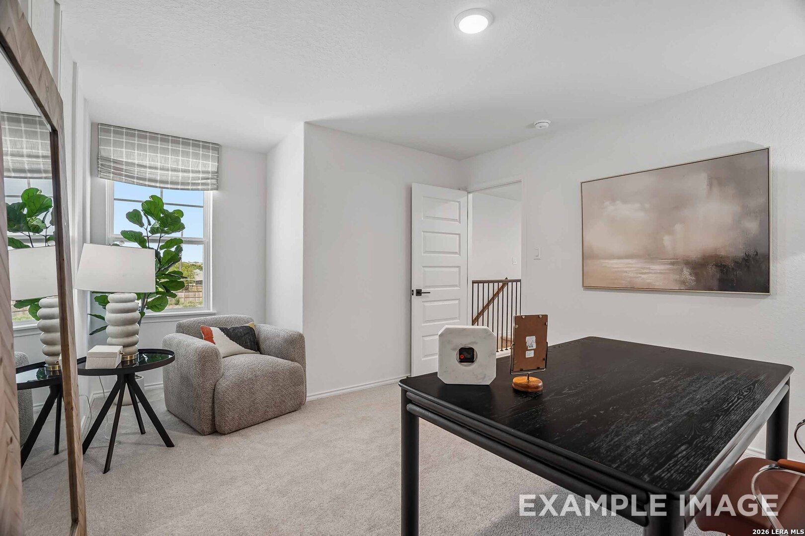 Bright upstairs bedroom with sitting area, cozy armchair, and black desk in Davidson Homes The Pinecrest E, Fairway Crossing, Converse TX