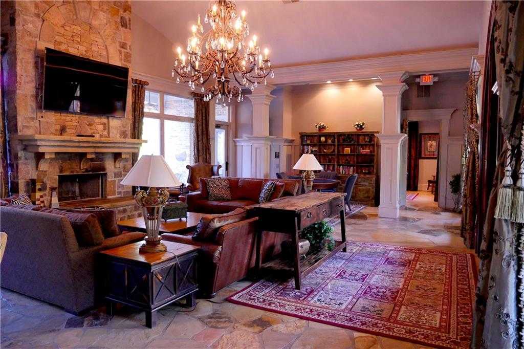Elegant living room with stone fireplace, crystal chandelier, and sectional sofa in Davidson Homes The Seaside B, Woodstock, Georgia