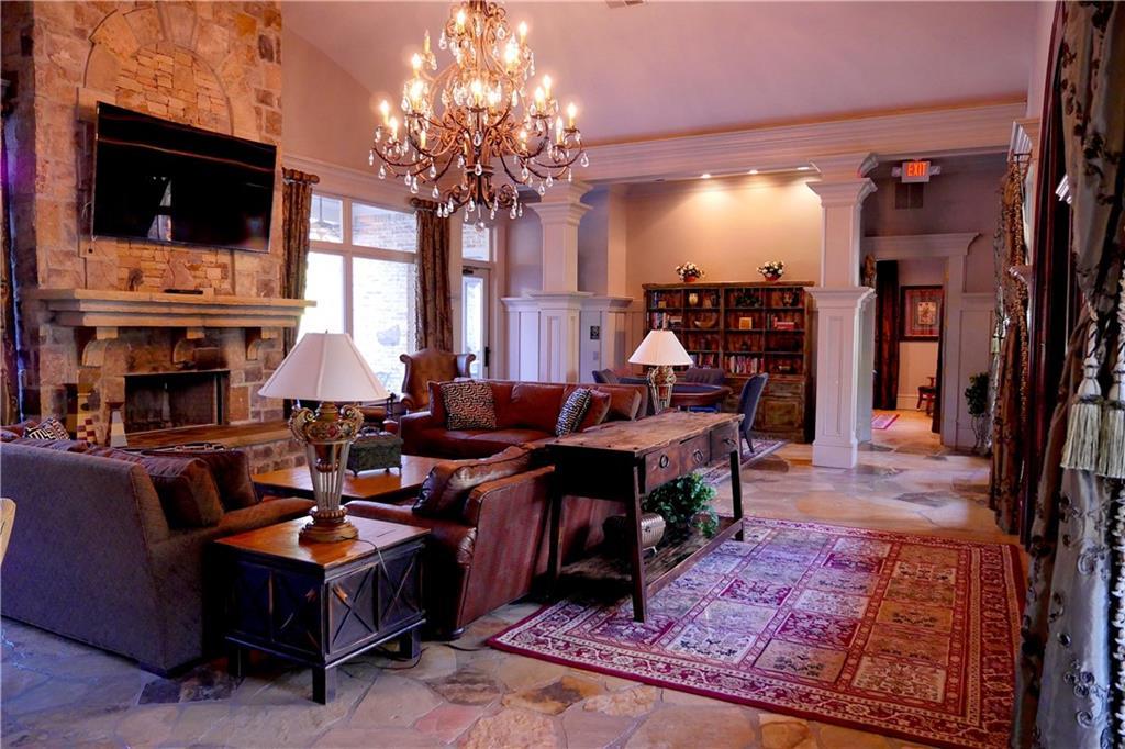 Elegant living room with stone fireplace, crystal chandelier, and sectional sofa in Davidson Homes The Seaside B, Woodstock, Georgia