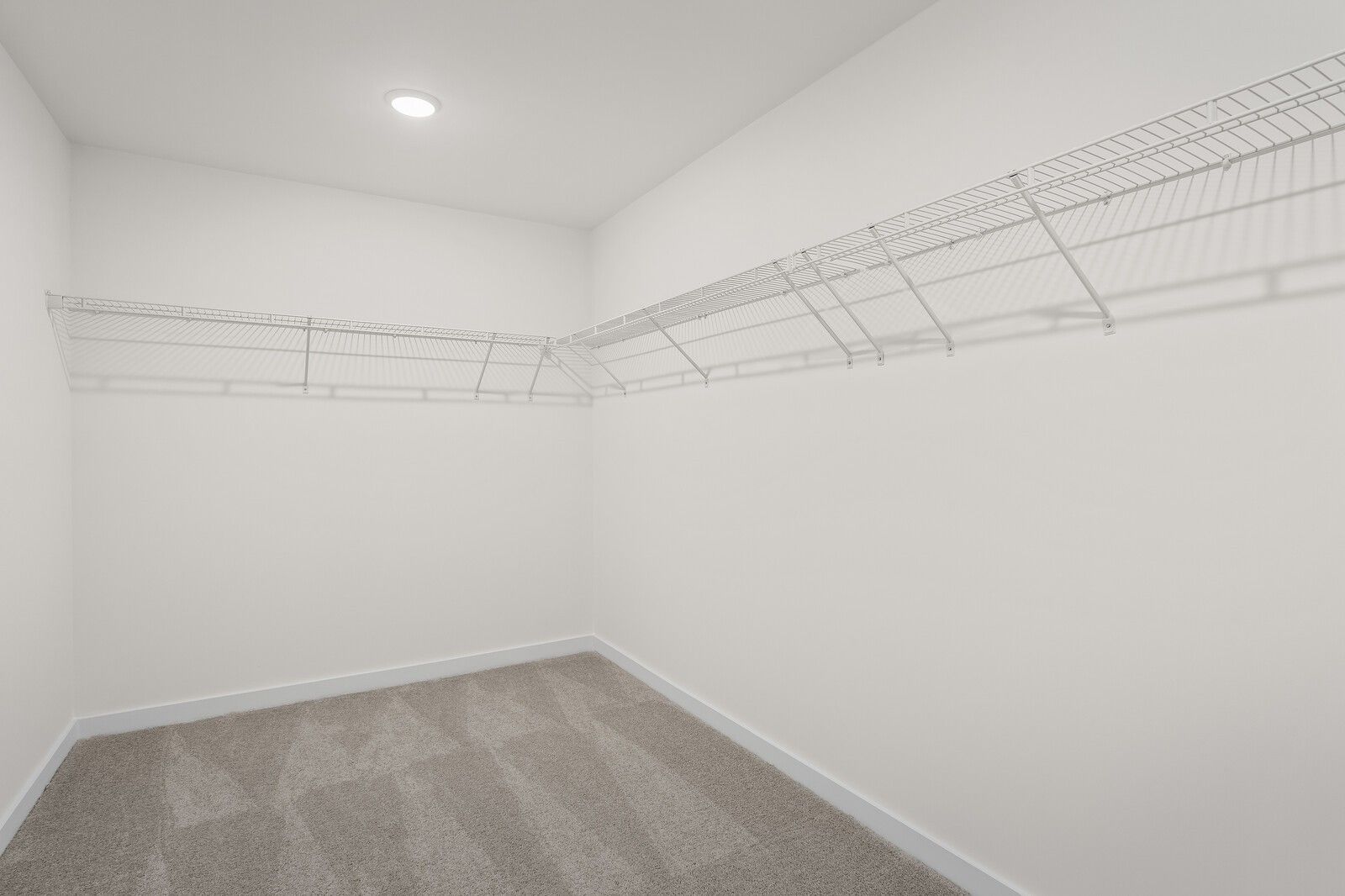 Spacious walk-in closet with white wire shelving in The Henry C floor plan at Benders Cove, Mt. Juliet, Tennessee.