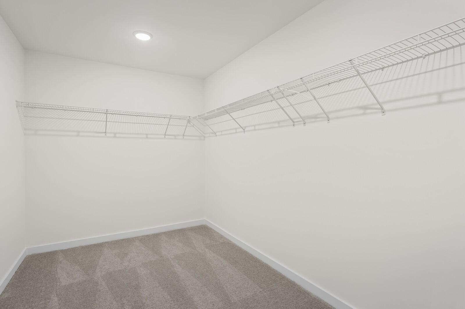 Spacious walk-in closet with white wire shelving in The Henry C floor plan at Benders Cove, Mt. Juliet, Tennessee.