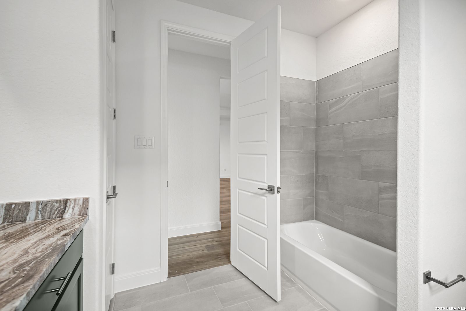 Modern bathroom with gray tile shower surround in The Lanier G floor plan at The Reserve at Potranco Oaks, Castroville, TX.