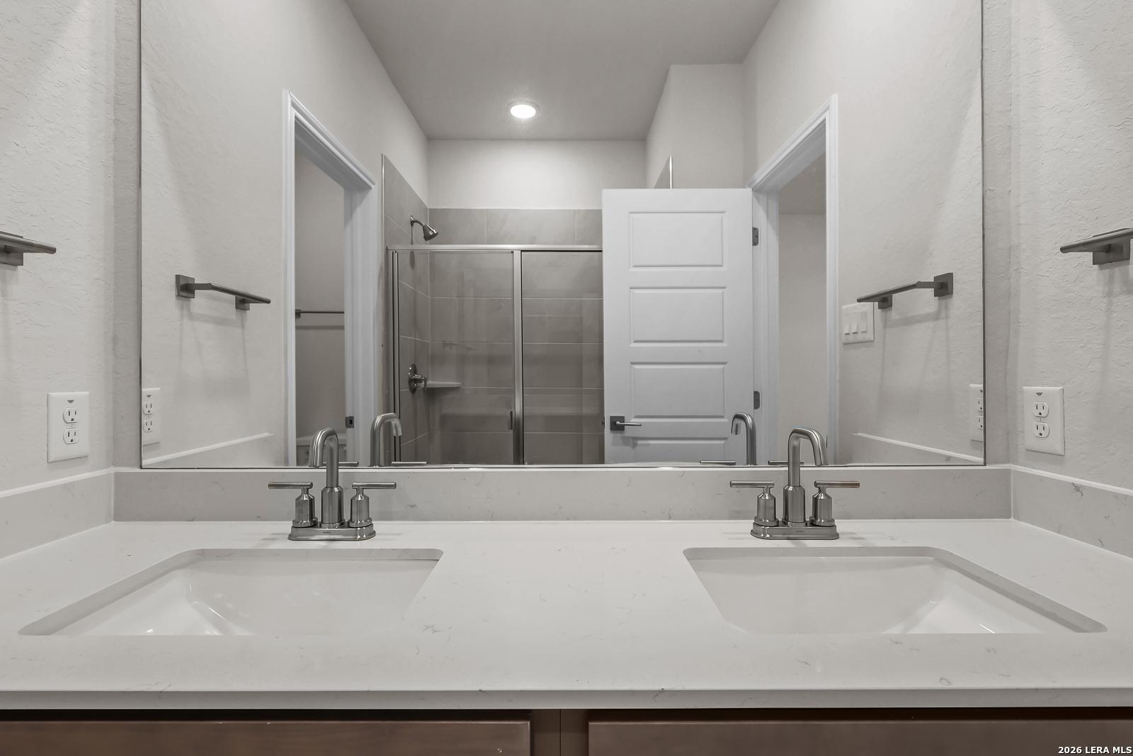 Dual vanity bathroom with quartz countertops in Davidson Homes The San Marcos F floor plan, Rayburn Valley, San Antonio.