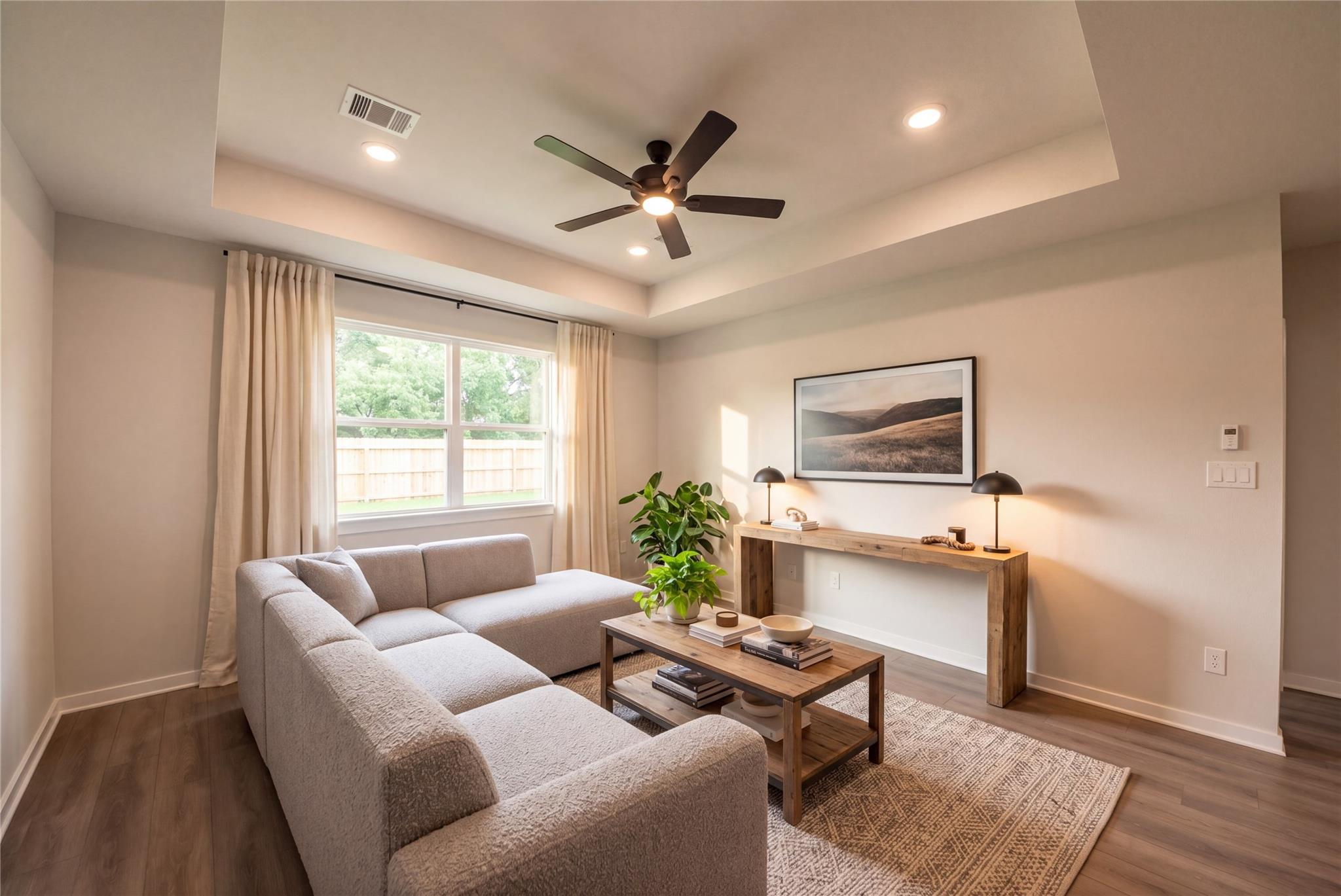 Cozy living room with sectional sofa, ceiling fan, and wood accents in Davidson Homes' Daphne F floor plan, Sundance Cove, Crosby, TX