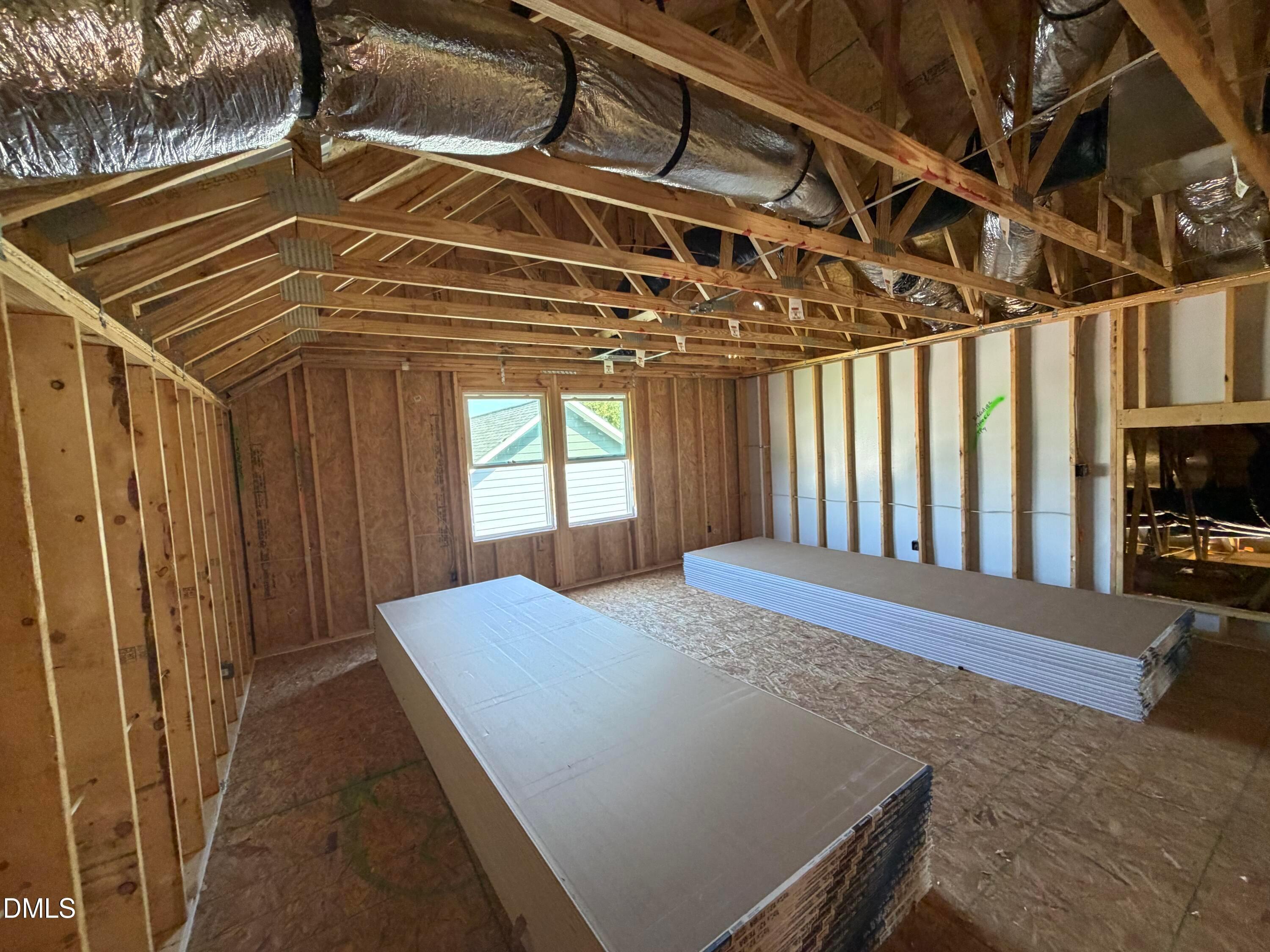 Unfinished upstairs bonus room with exposed framing and ductwork in The Aspen C floor plan by Davidson Homes, Wendell Ridge, NC