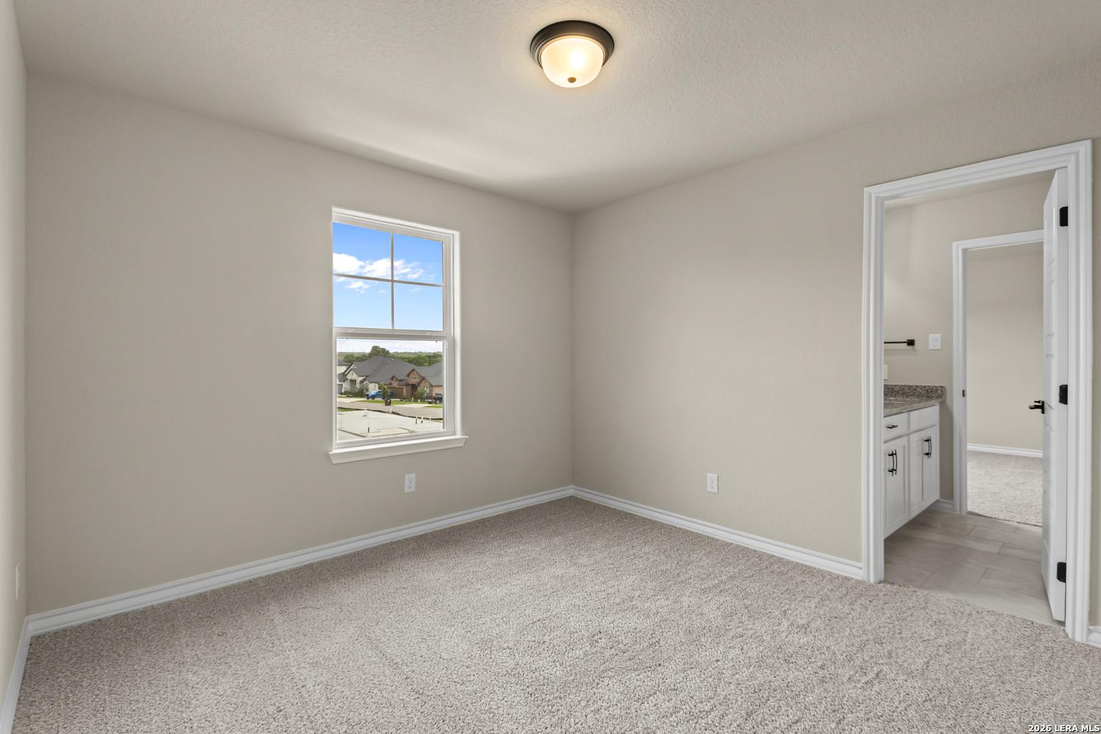 Spacious secondary bedroom with ensuite bathroom in The Danbury H floor plan at The Reserve at Potranco Oaks, Castroville.