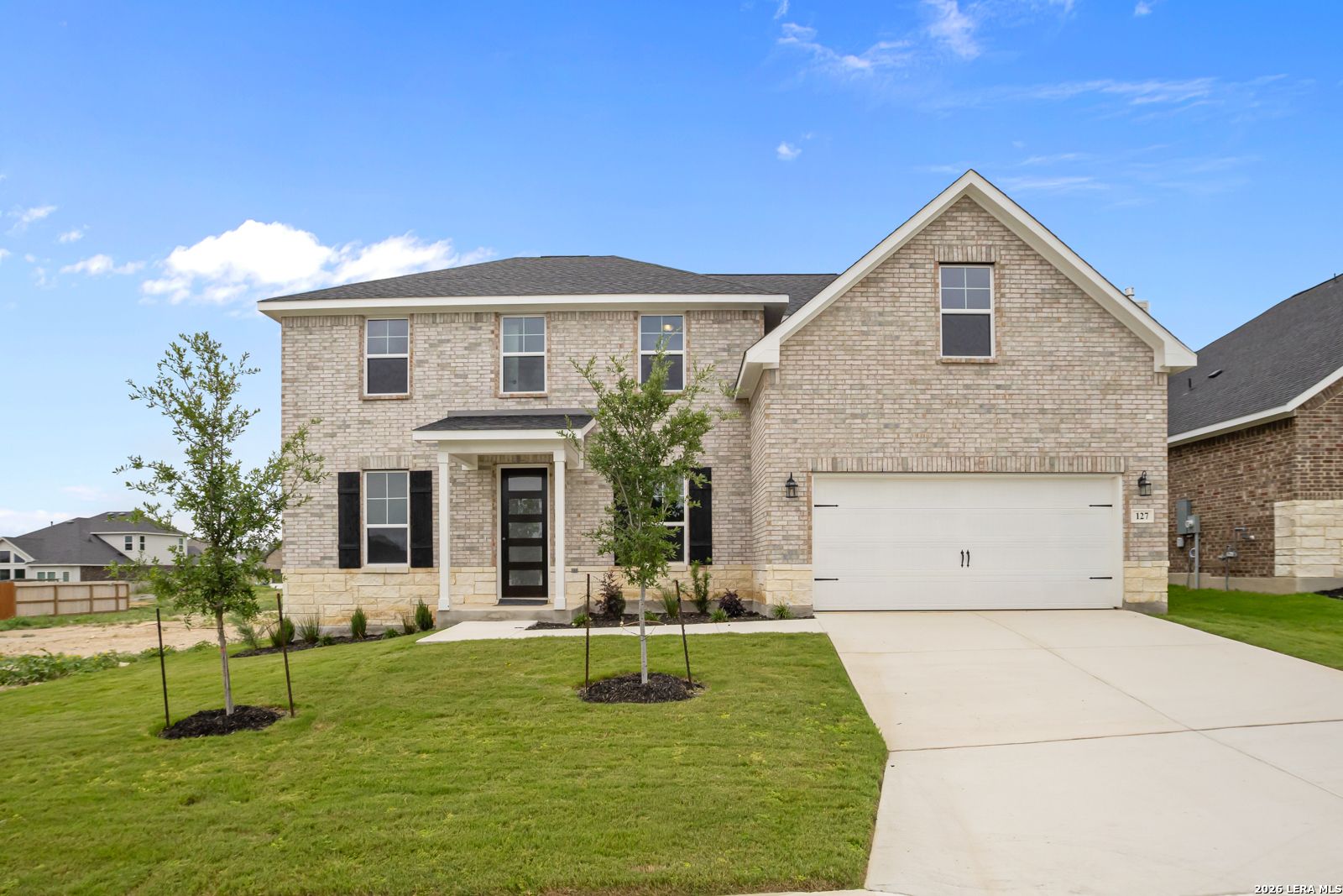 Two-story brick home featuring The Danbury H floor plan by Davidson Homes in The Reserve at Potranco Oaks, Castroville, TX.