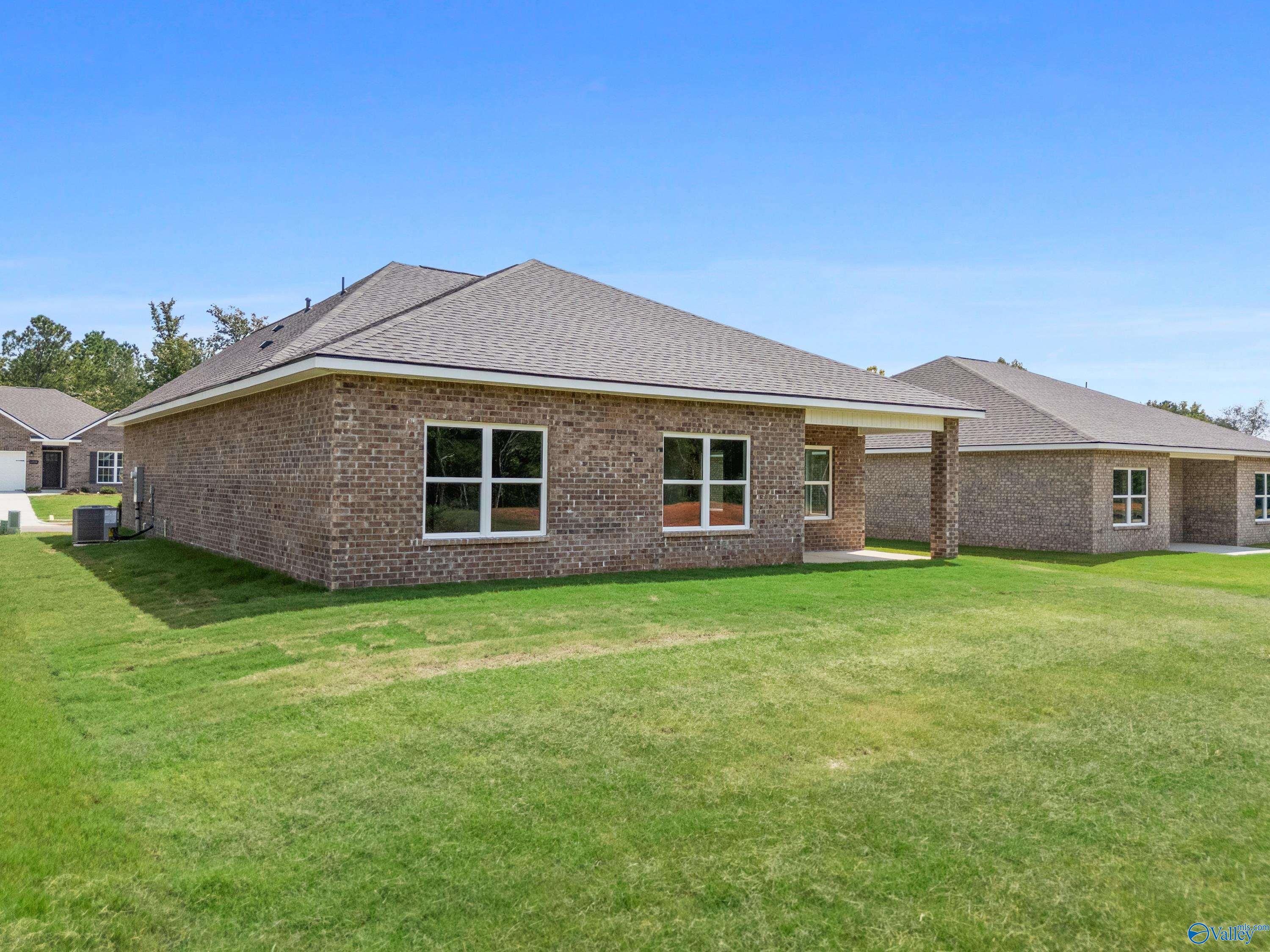 Brick single-story home with 2-car garage, covered patio, and lush green lawn in Spragins Cove, Huntsville, AL - Davidson Homes Franklin C