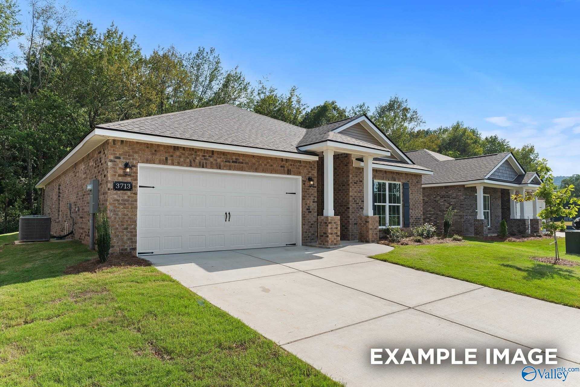 Brick one-story home with 2-car garage, brick accents, and lush landscaping in Heritage Lakes, New Market, Alabama