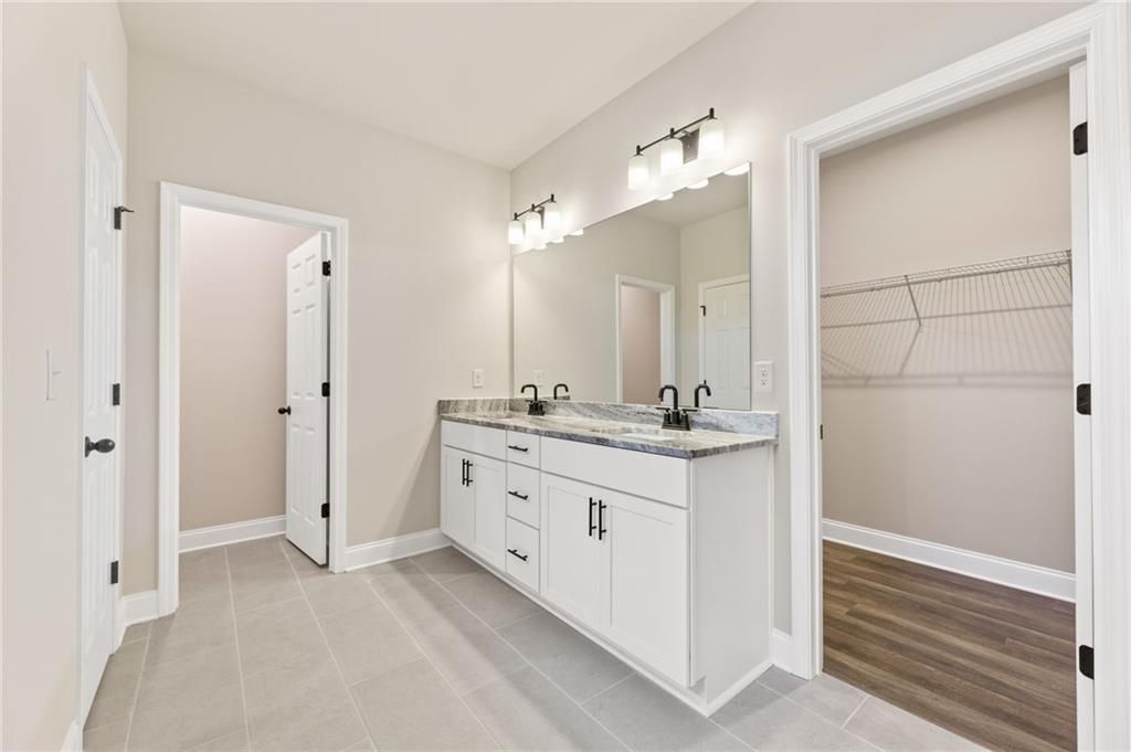 Elegant master bathroom with double vanity, quartz counters, and walk-in closet in Davidson Homes The Harrison H, Winder, GA