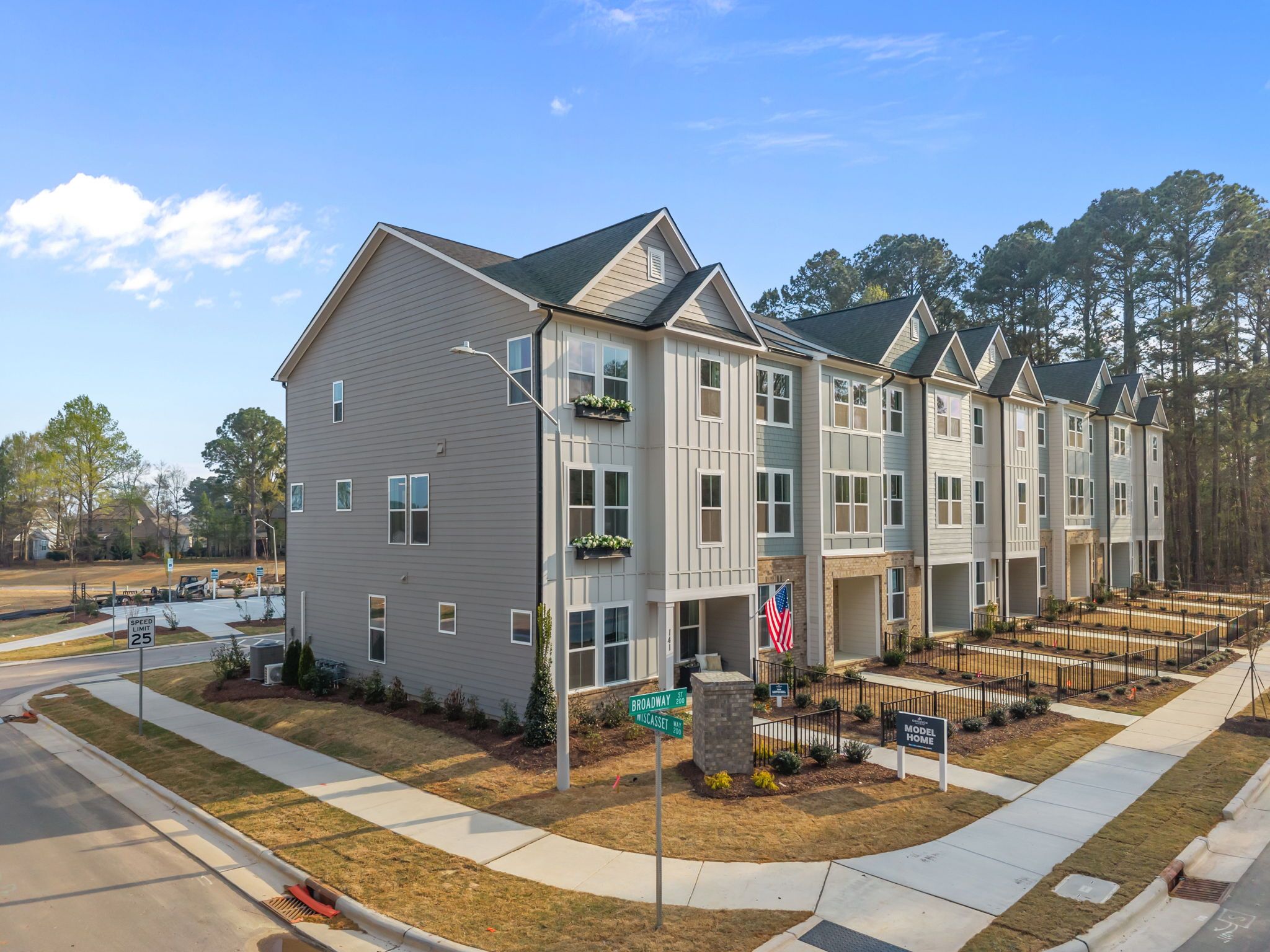 Row of modern townhomes at Camden Park in Knightdale NC with gabled roofs, flower boxes and pine landscaping