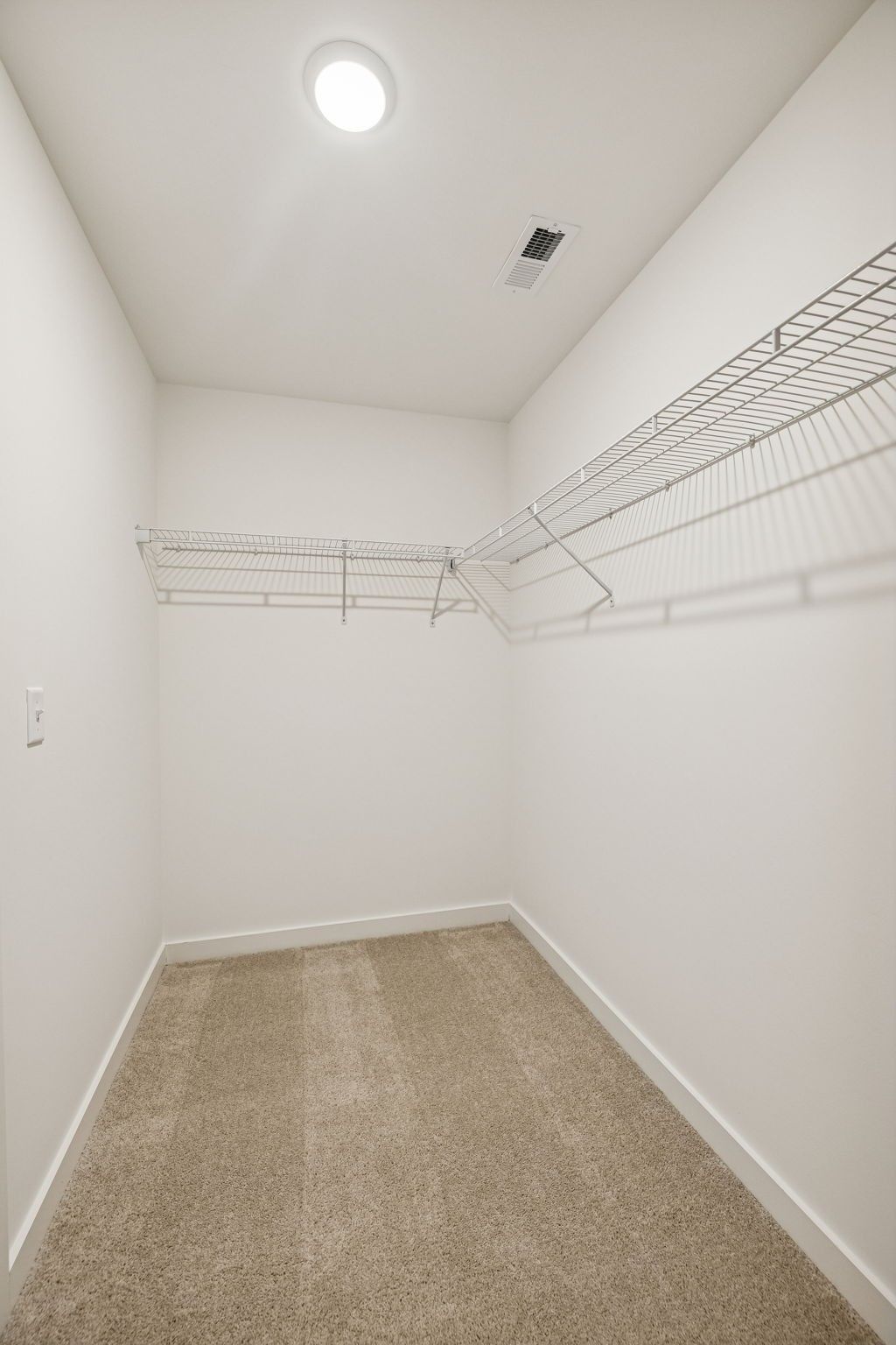 Spacious walk-in closet with wire shelving, beige carpet, and recessed lighting in Davidson Homes The Willow, Calista Farms, White House, TN