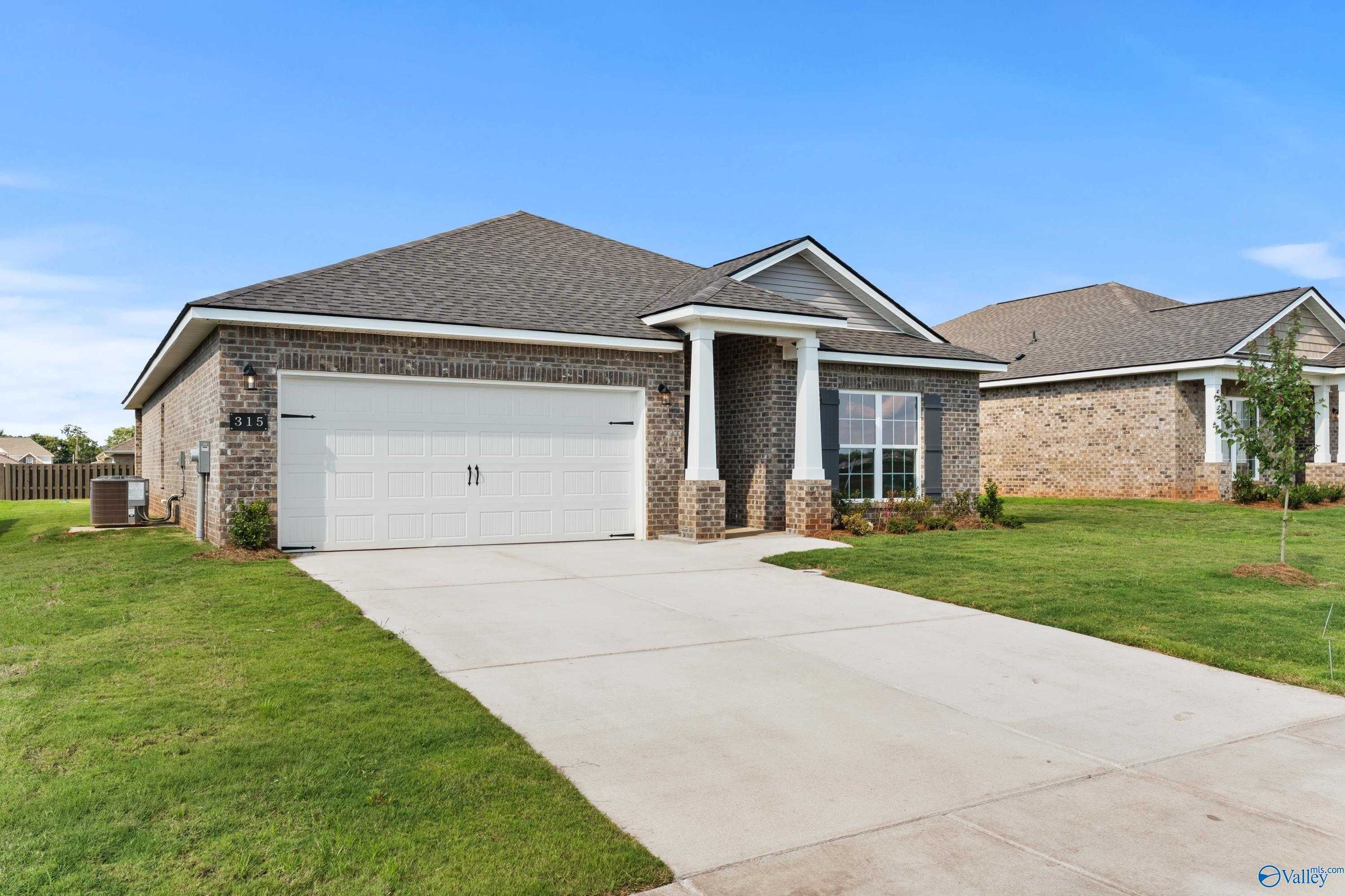 Modern brick ranch home with 2-car garage, covered porch, and lush lawn in Clearview, Hazel Green, AL - Davidson Homes Daphne