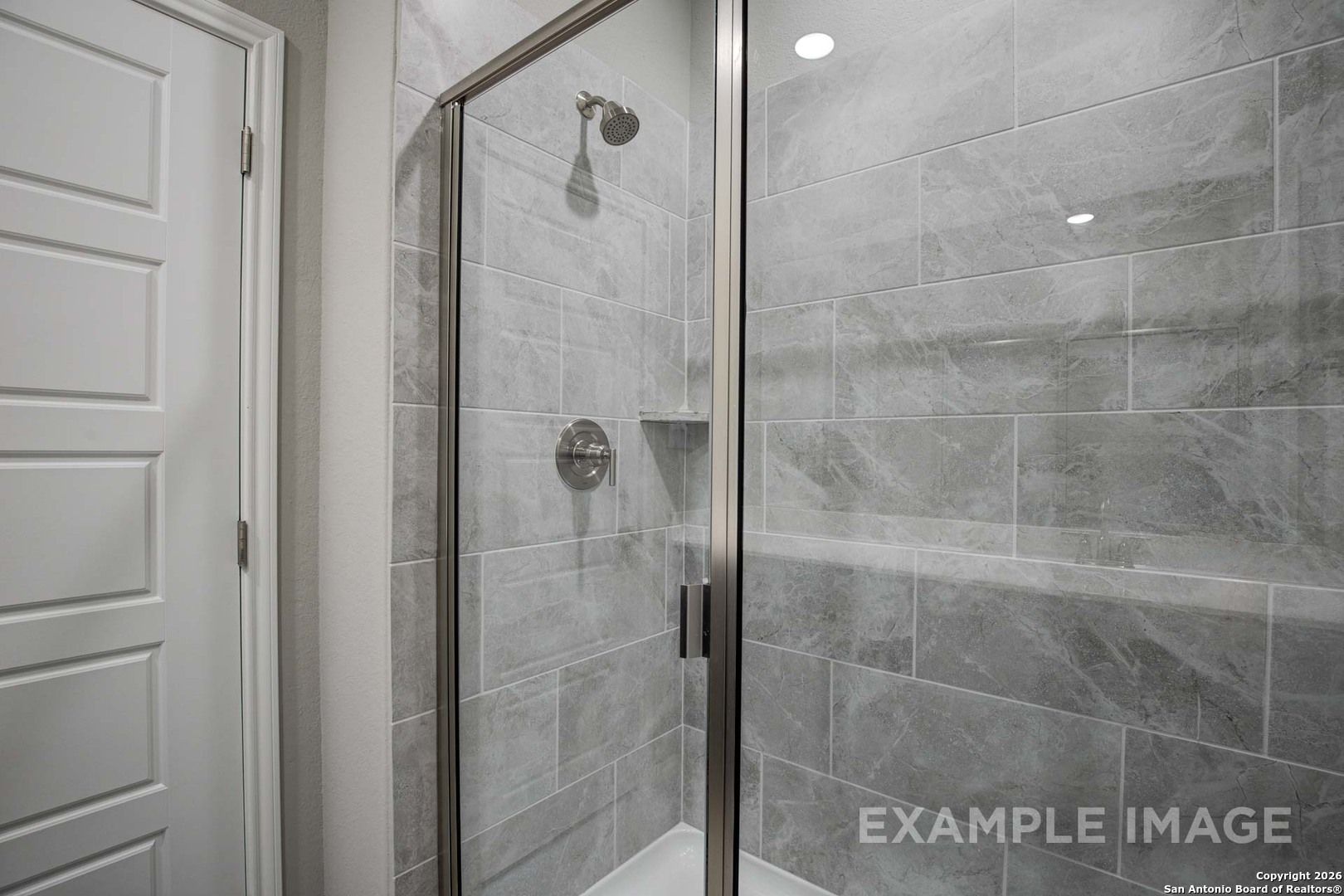 Modern glass-enclosed walk-in shower with gray subway tiles in master bathroom, Davidson Homes The Frio B, San Antonio