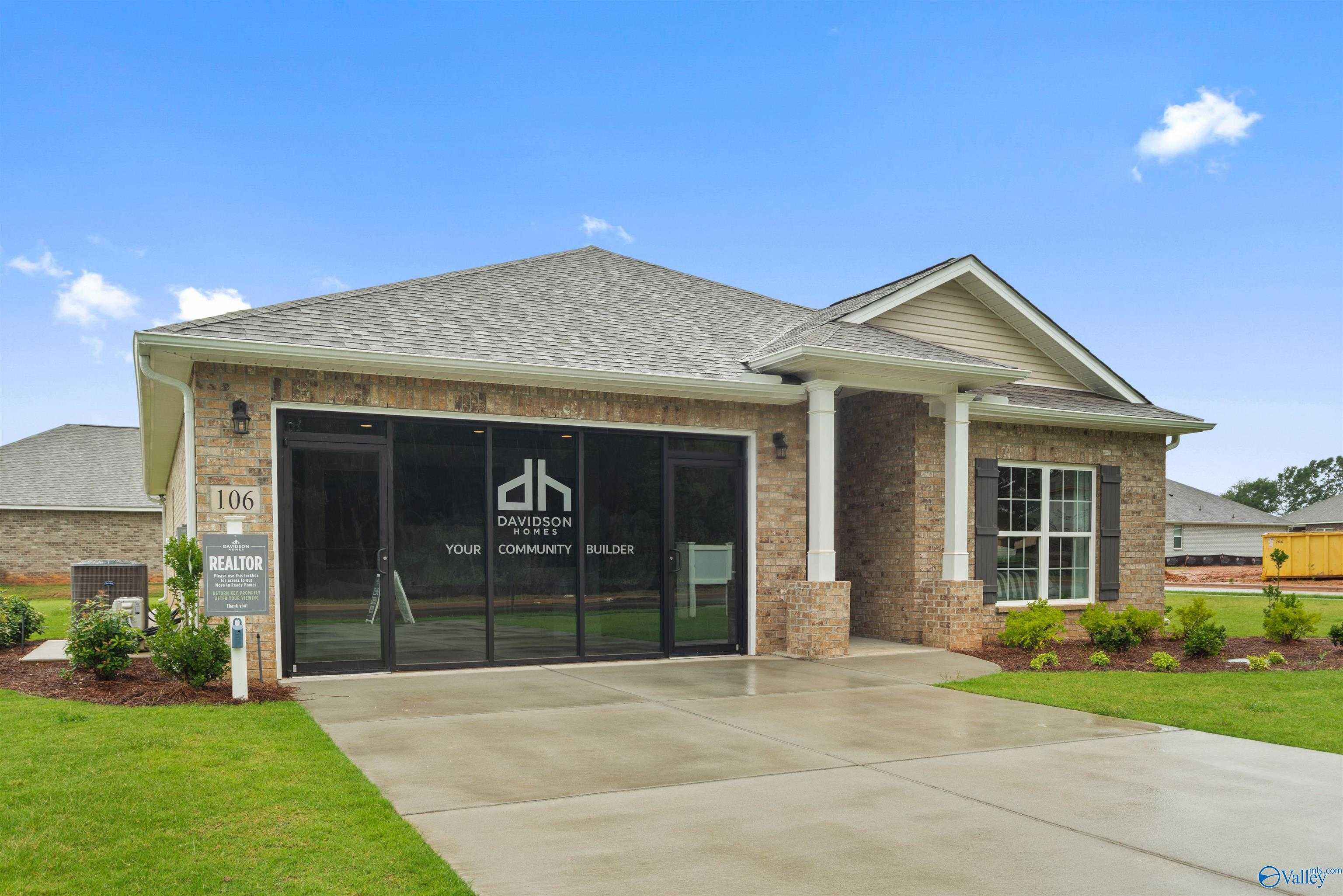 Modern single-story 4-bedroom home with brick facade, 2-car garage, and covered porch by Davidson Homes in Durham Farms, Harvest, Alabama