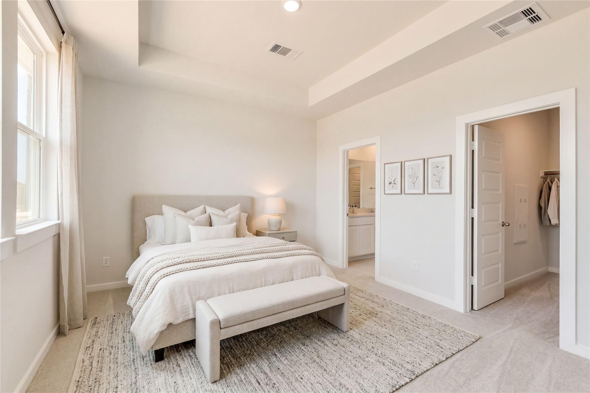 Serene master bedroom with king bed, neutral decor, en-suite bath, walk-in closet in Davidson Homes The Frio G, Conroe, Texas