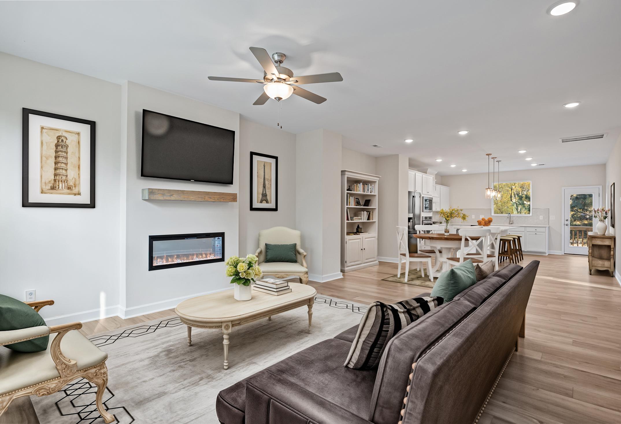 Open-concept living room in The Avery featuring a modern fireplace, stylish seating, and views into the gourmet kitchen.