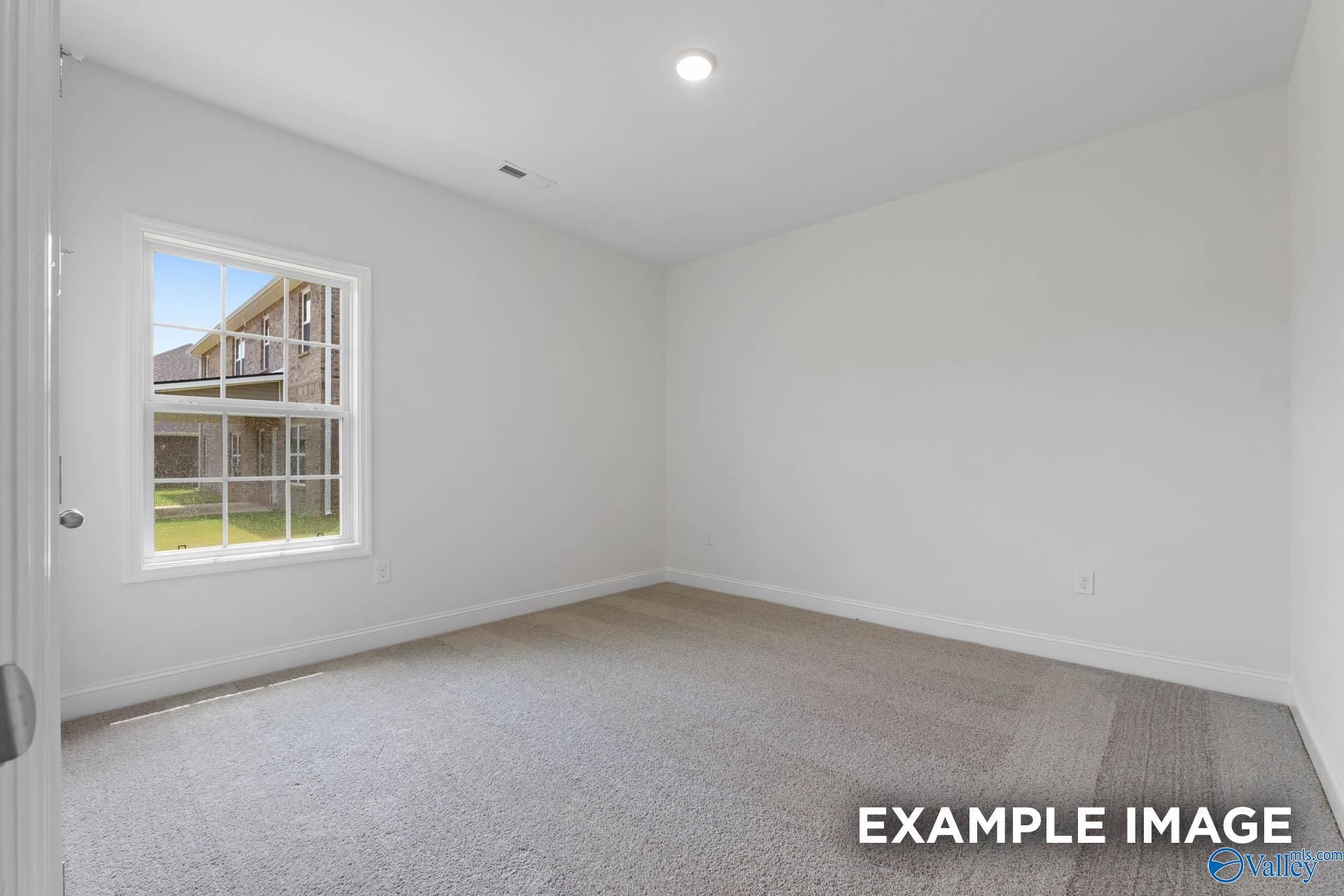 Bright empty bedroom with large window viewing lush lawn in 4-bedroom Davidson Homes The Oxford, Riverton Preserve, Huntsville, Alabama