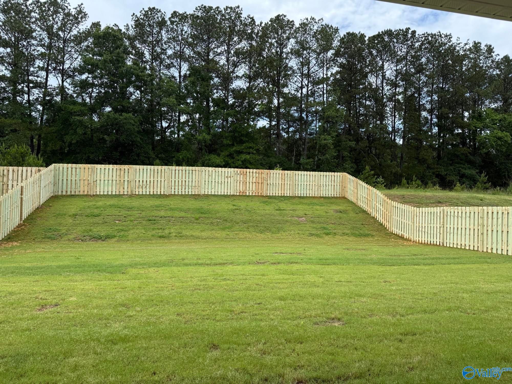 Spacious, fenced-in backyard with lush green lawn at The Rockford B home in Cain Park, Hartselle, Alabama.